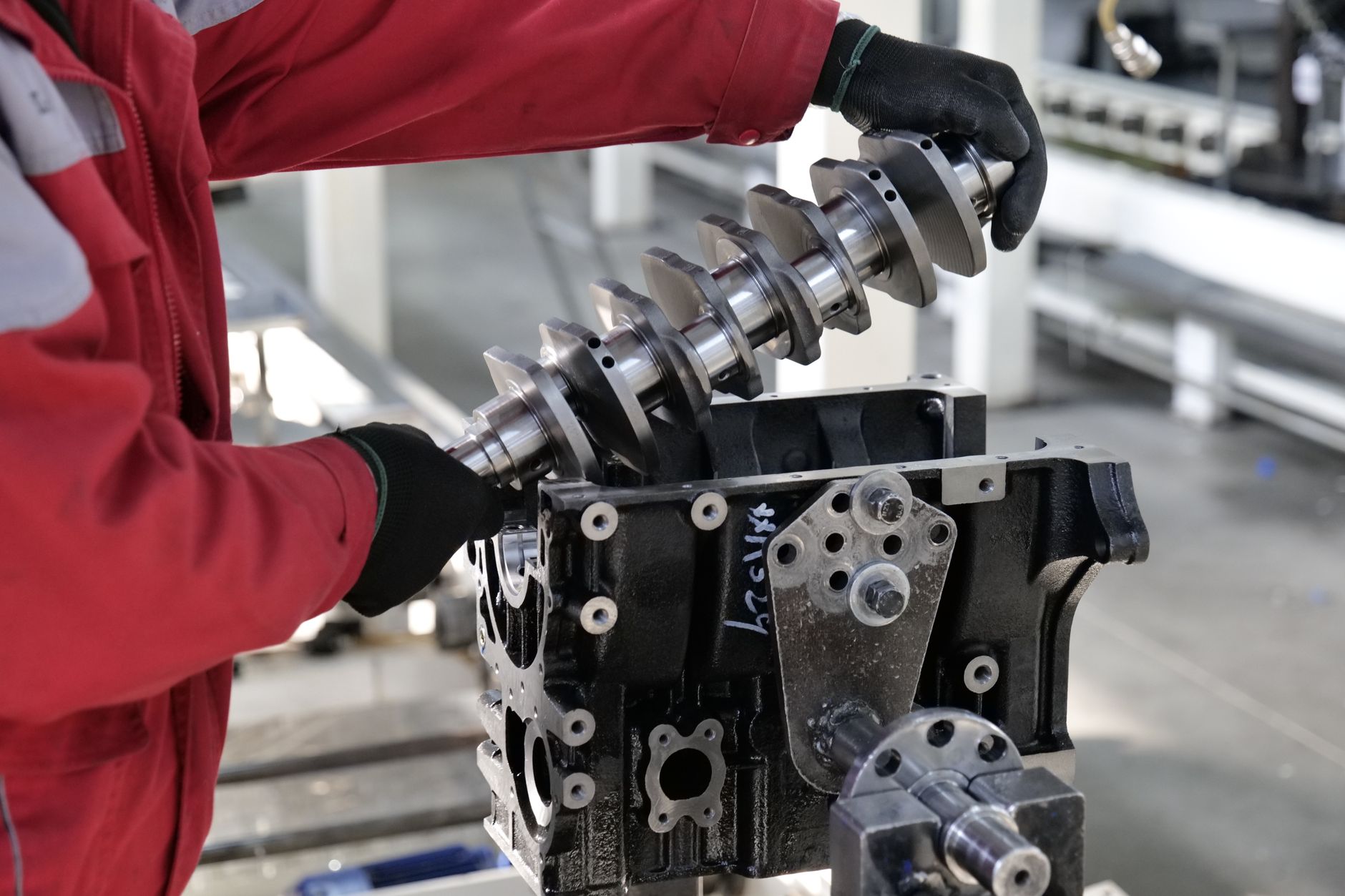 Workers assemble large generator units on an industrial production line.