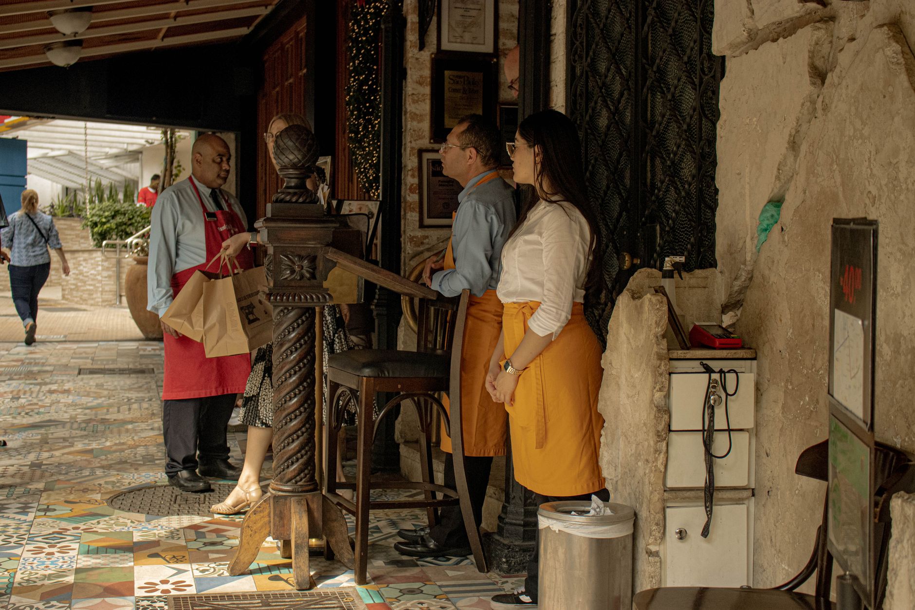Restaurant staff gathered for a pre-shift discussion, reflecting the human service focus operators want to protect while repetitive runs are handled in the background.