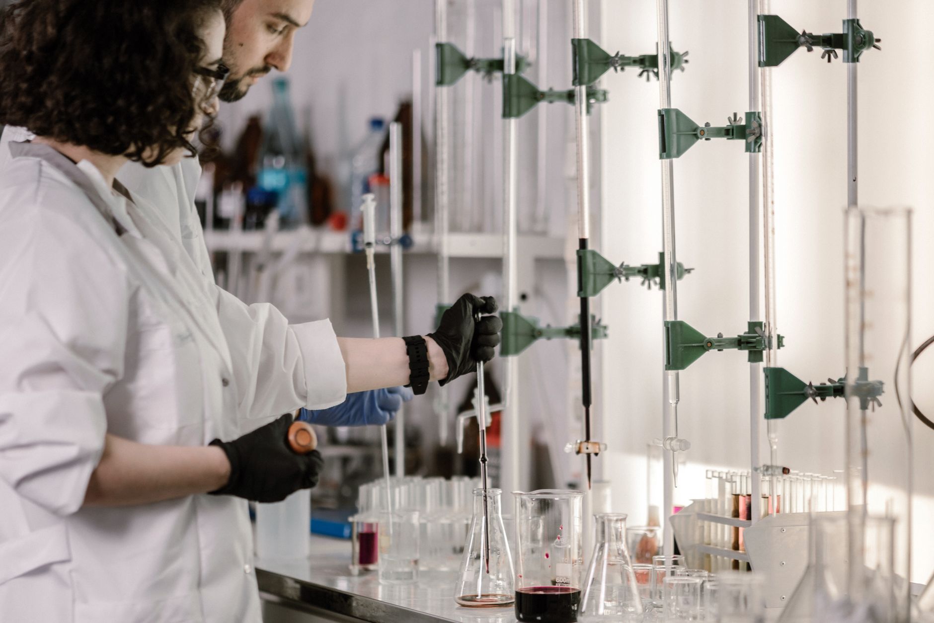 A craftsperson inspecting finished laboratory glassware for consistent shape and quality.
