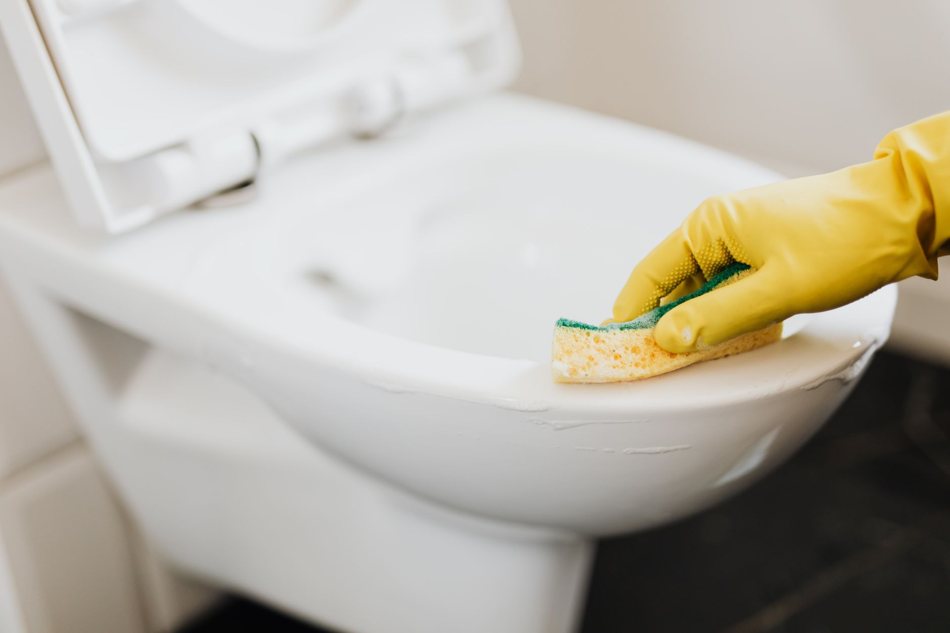 A cleaner working in a commercial restroom, reflecting how staff time can shift to tasks that still need human hands.
