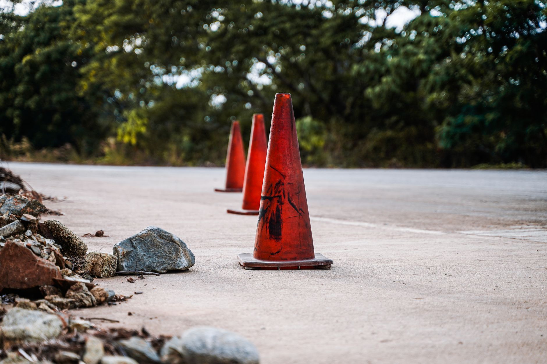 Traffic cones marking a brief lane control period on a highway deck during infrastructure work.