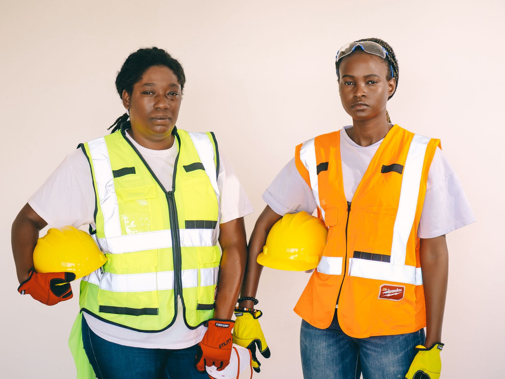 Construction workers in hard hats on an active job site, illustrating the reduced two-person crew after automating the spray step.