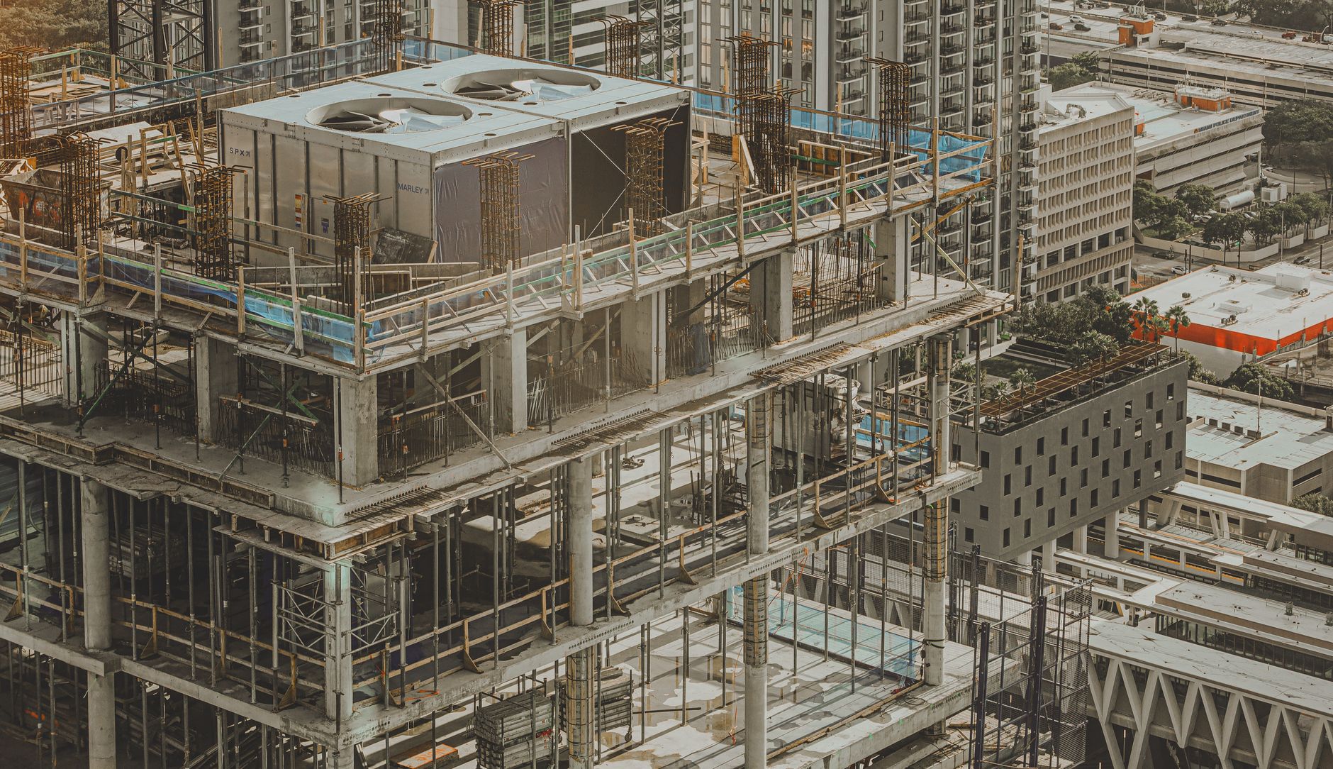 Steel columns and decking on an active high-rise construction site like the Tokyo hotel tower where fireproofing spray was automated.