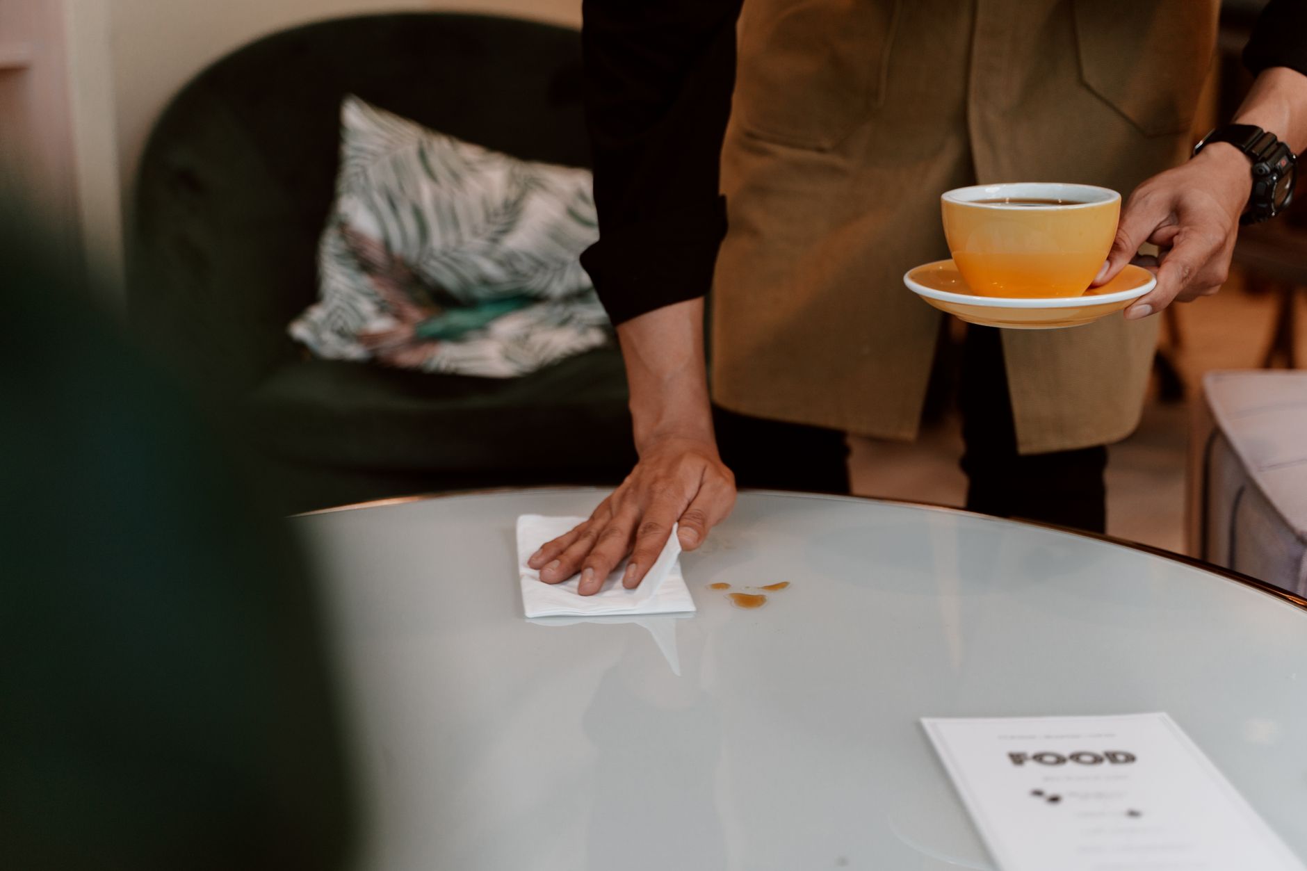 Restaurant staff clearing used plates from guest tables, illustrating the repetitive transport work that was reduced in the case study.