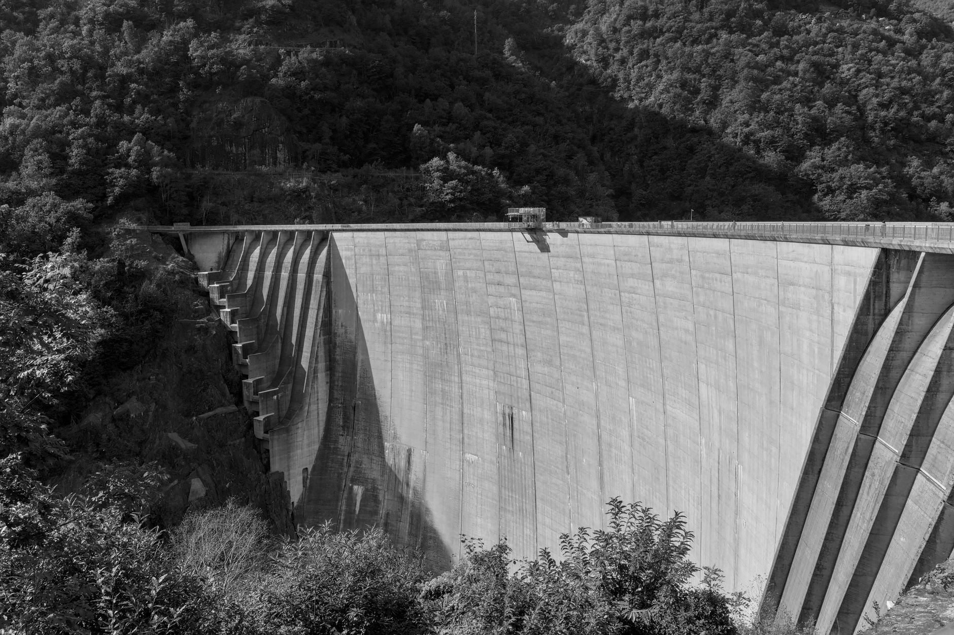 Massive concrete surfaces inside a hydropower dam where inspectors map cracks over time.