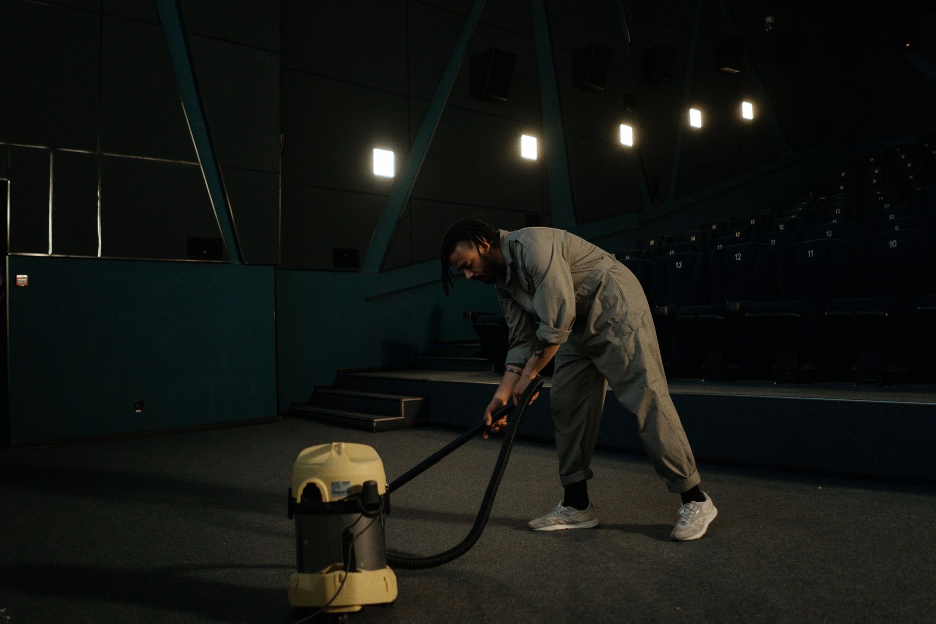 A commercial cleaner vacuuming office carpet during a scheduled floor-care shift.