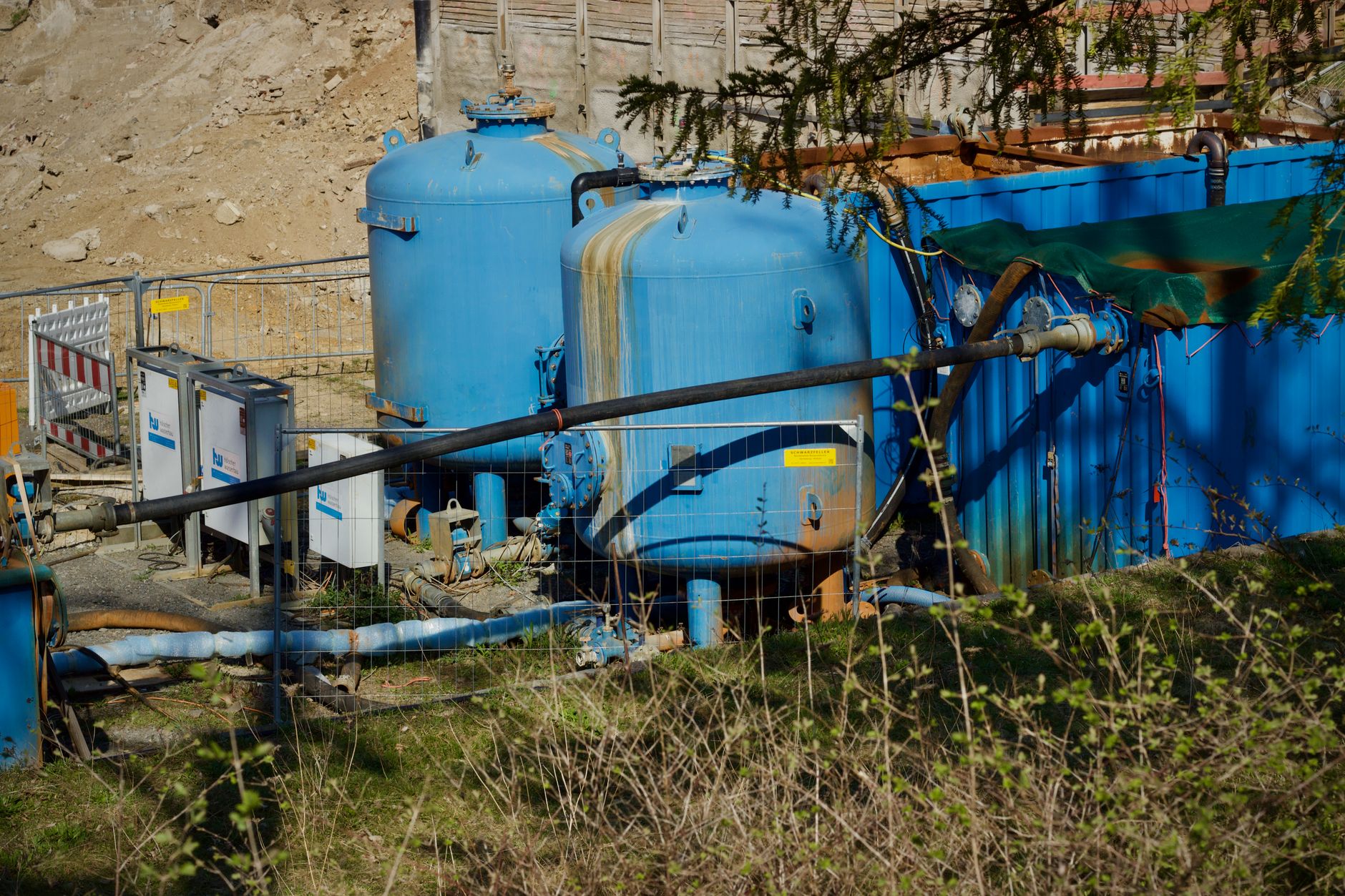 Large vertical water tank walls inside an industrial processing building.