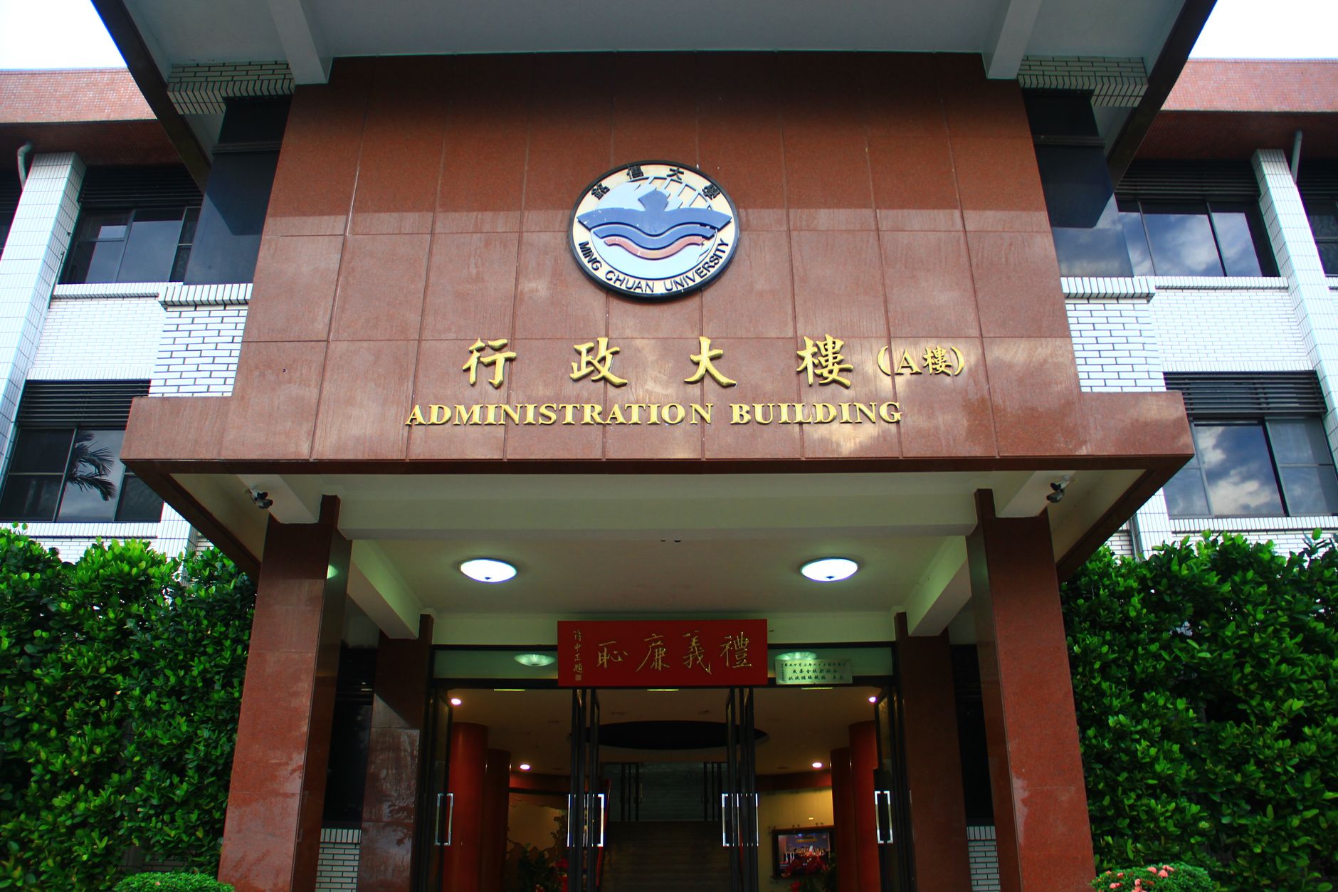 Students passing through a campus building entrance with hard flooring, illustrating the foot traffic higher education facilities must keep clean.