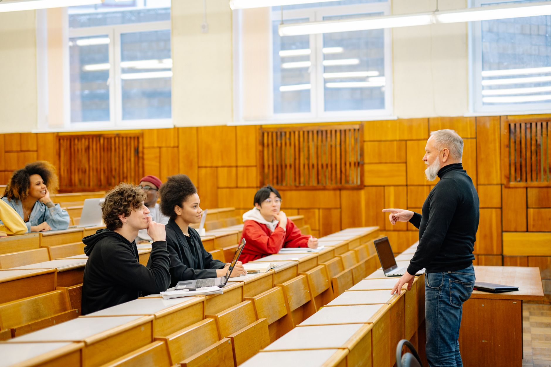 Wide view of a university lecture hall with rows of seats and a polished hard floor, evoking the scale of campus corridors that need daily scrubbing.