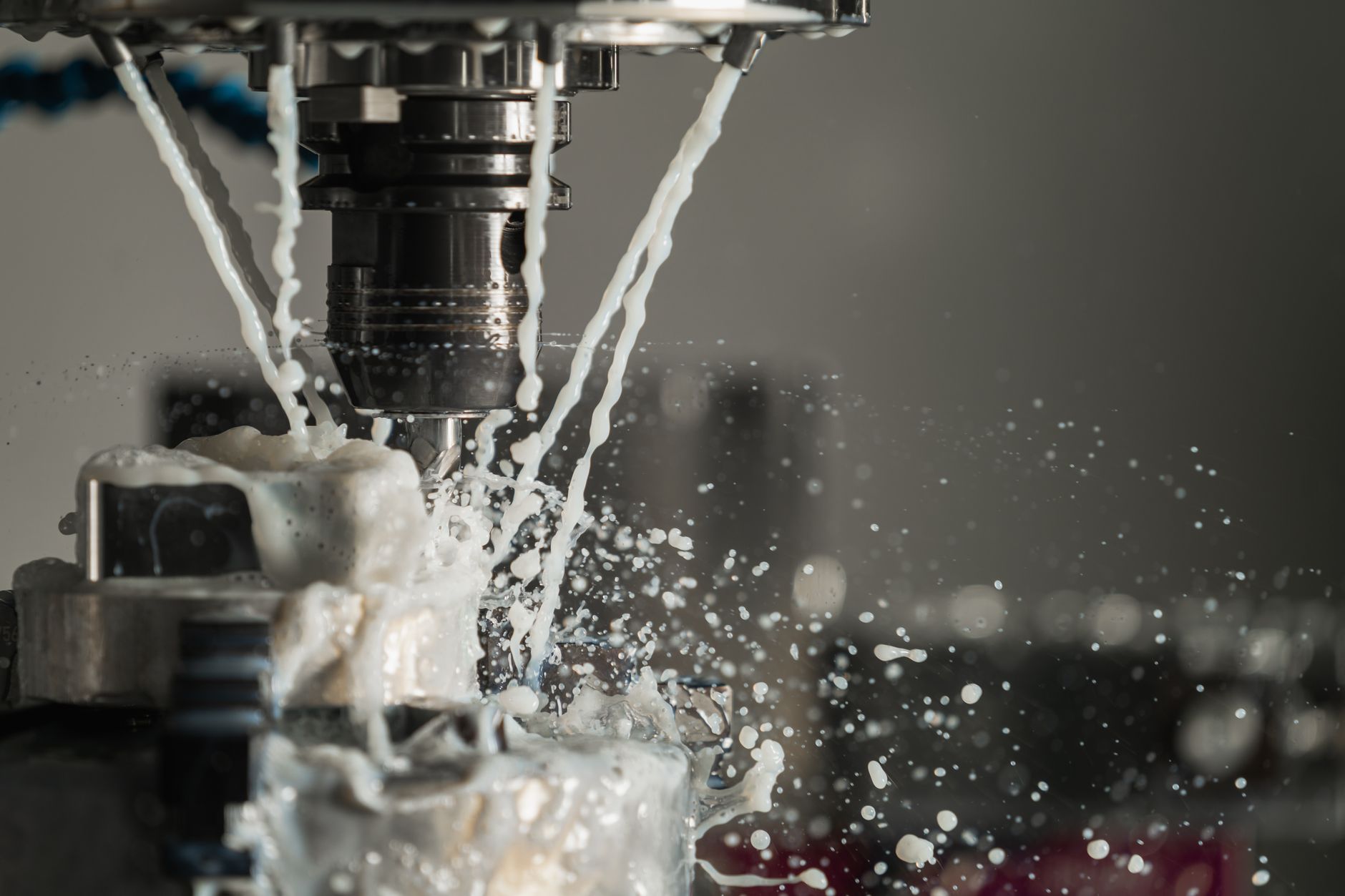 A machinist works among CNC equipment on a busy machine-shop floor.