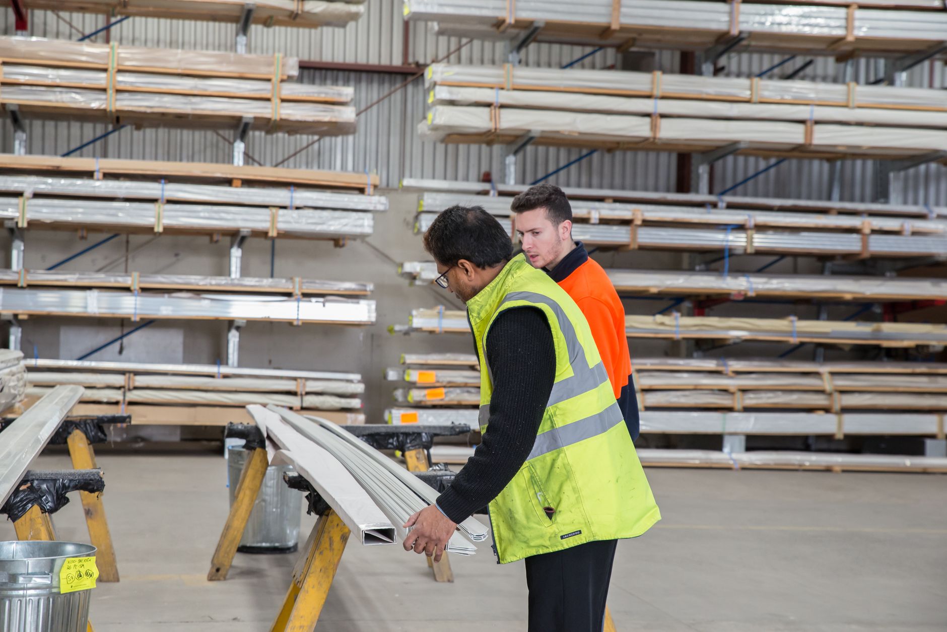 A worker inspecting a clear warehouse floor during preparation for overnight cleaning.