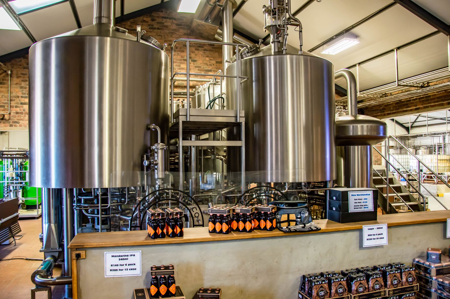 A busy brewery packaging floor with bottles moving along stainless-steel production lines.