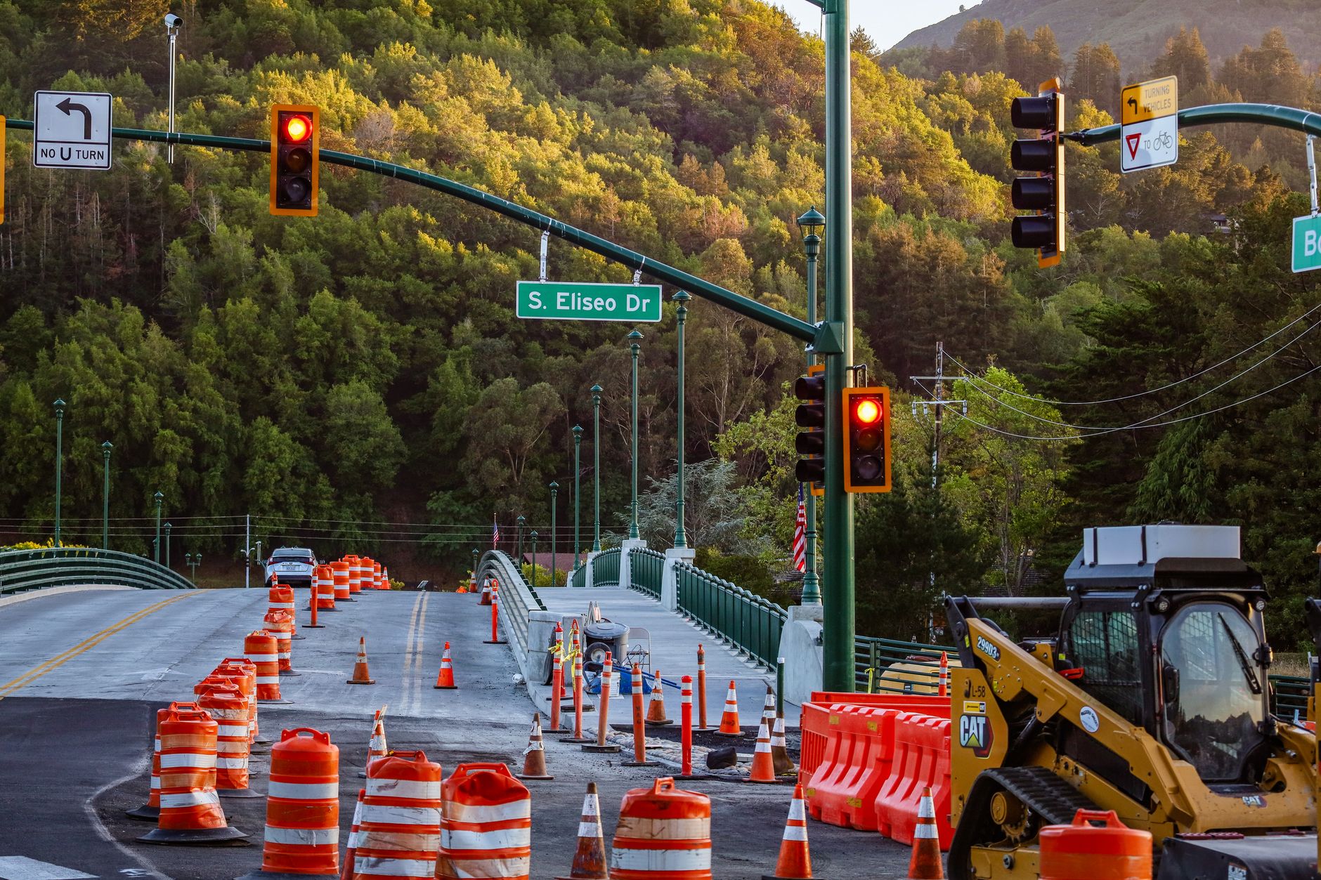 Lane closure cones and shifted traffic on a highway deck, illustrating the access disruptions inspection teams try to limit.