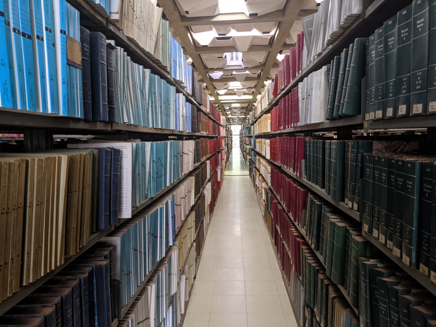 Library stacks and aisles where staff redirected time to detail work while floors were scrubbed autonomously.
