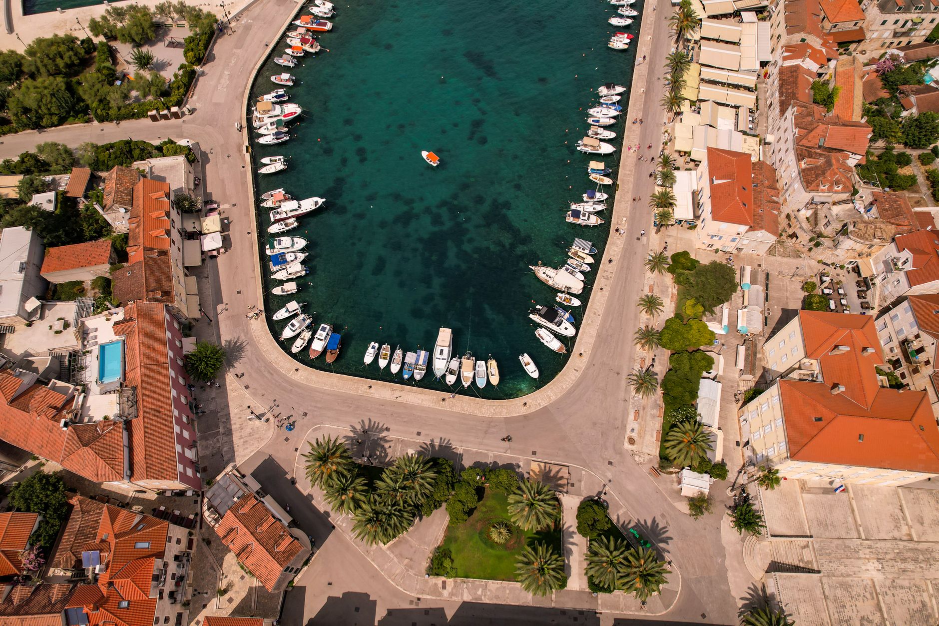 A Mediterranean marina filled with yachts and calm blue water along the coast.