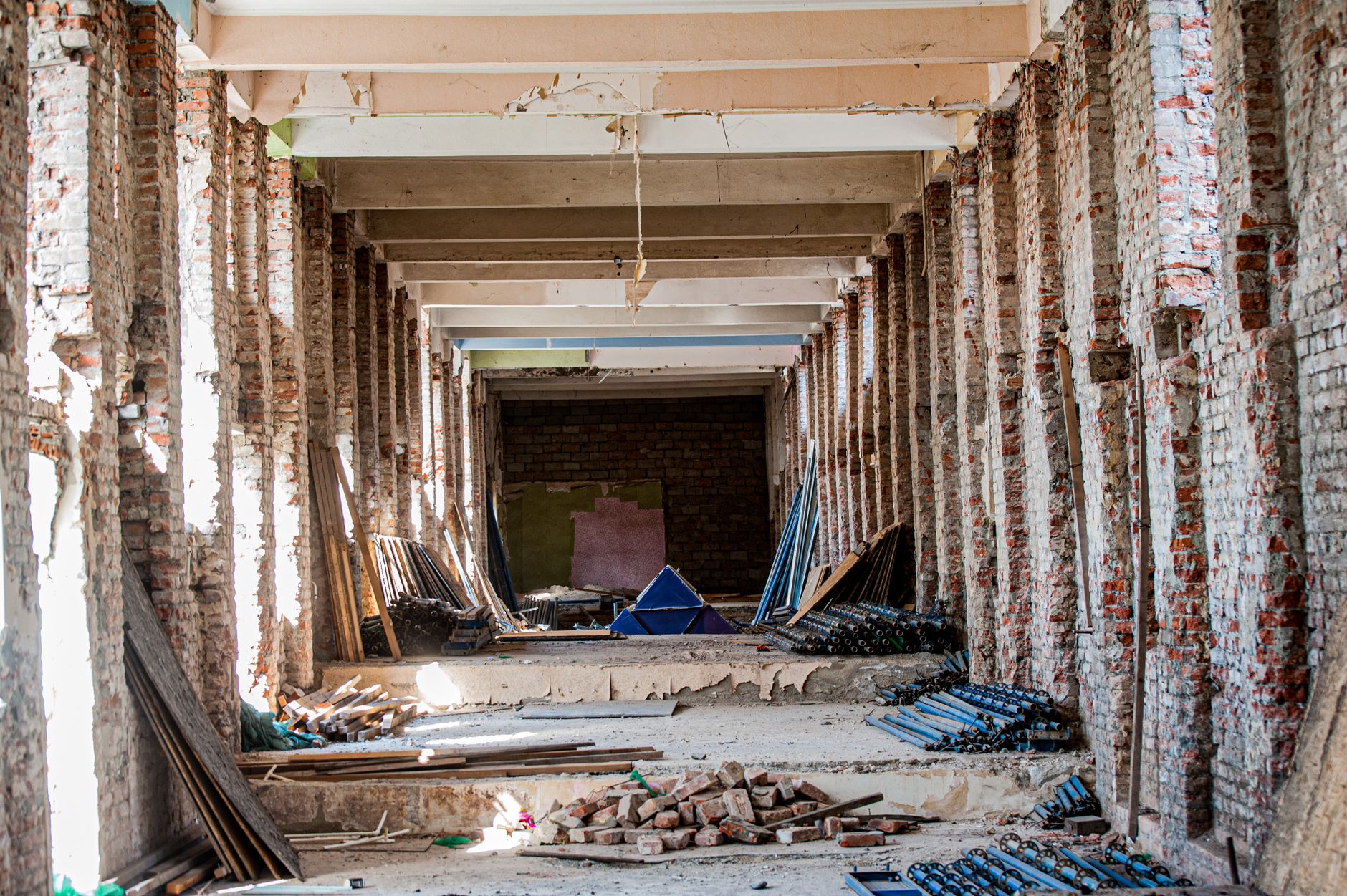 An unfinished medical building corridor shows the complex interior environment where multiple construction trades must coordinate their work.