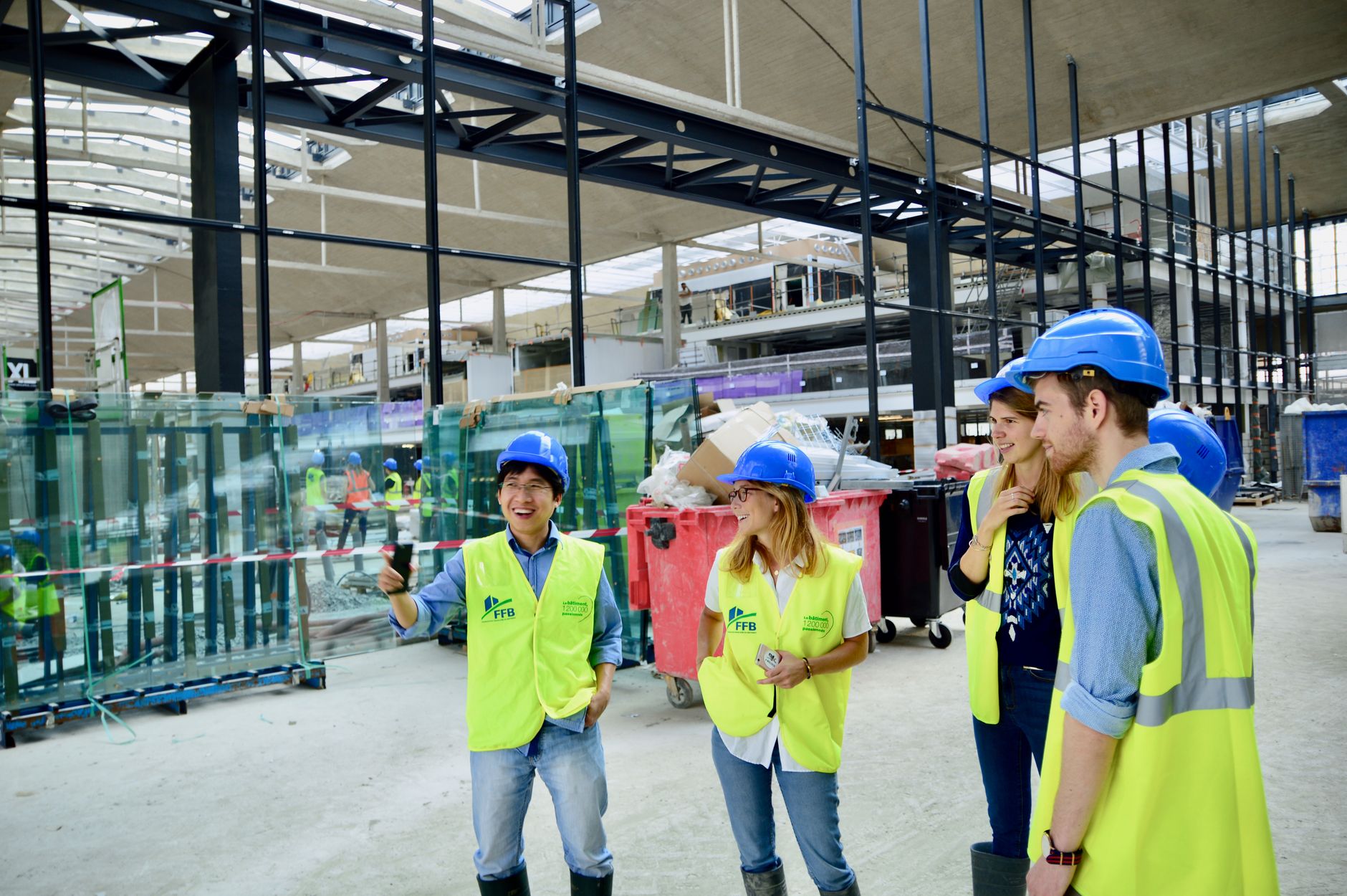 Contractors reviewing plans together inside an active commercial construction site.