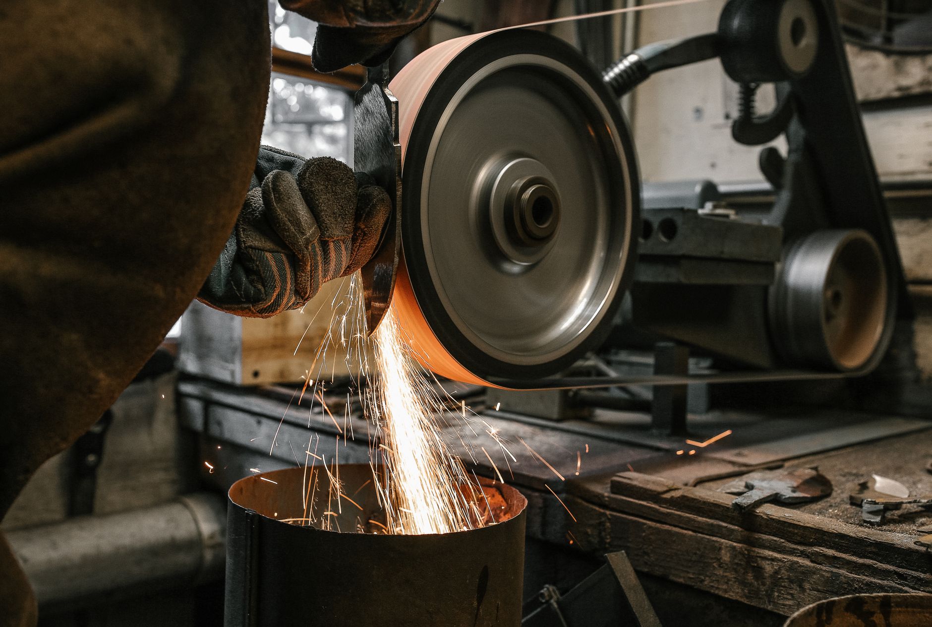 A busy metal fabrication shop with welders working among steel tables and unfinished parts.