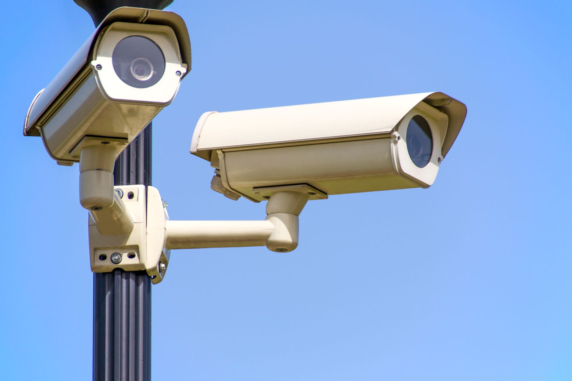 A parking-lot camera post representing the fixed camera-and-response devices paired with mobile patrol routes.