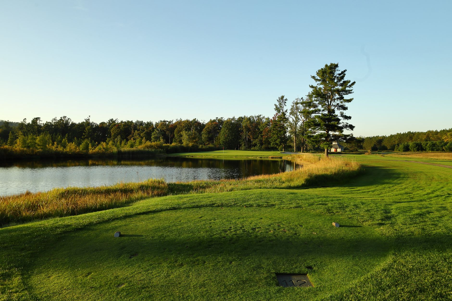 A tee box and closely cut surrounds ready for morning play