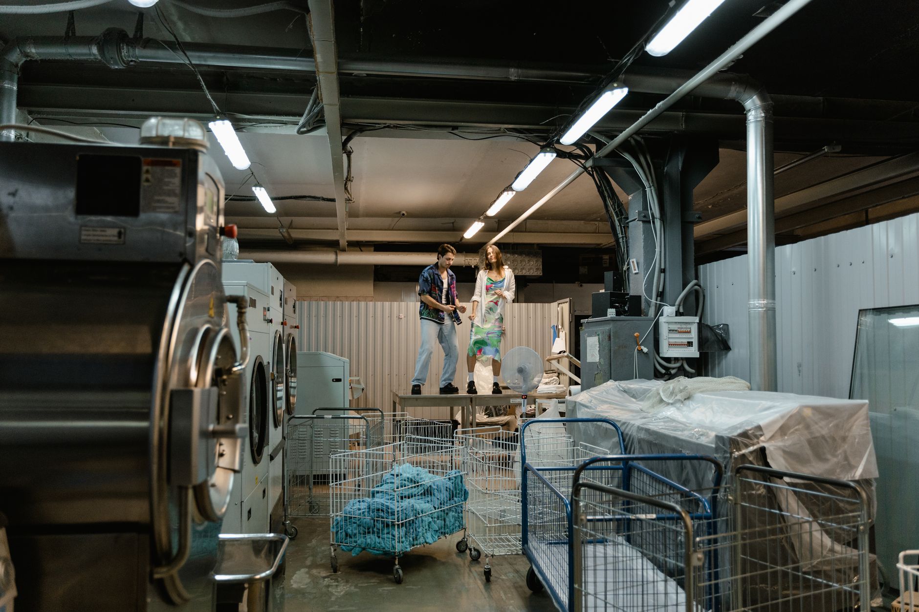 A linen cart in a clinical hallway represents the heavy loads EVS teams tow before automation takes over the long walks.