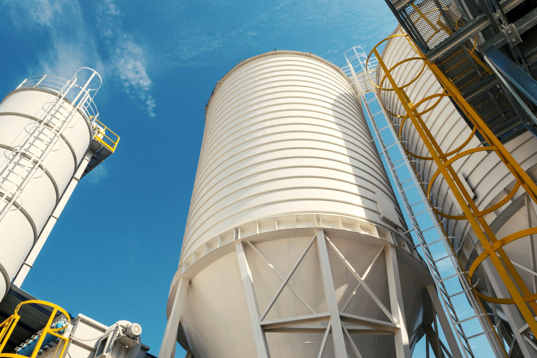 Large bulk material bins at a processing site like load-out vessels inspected from outside.