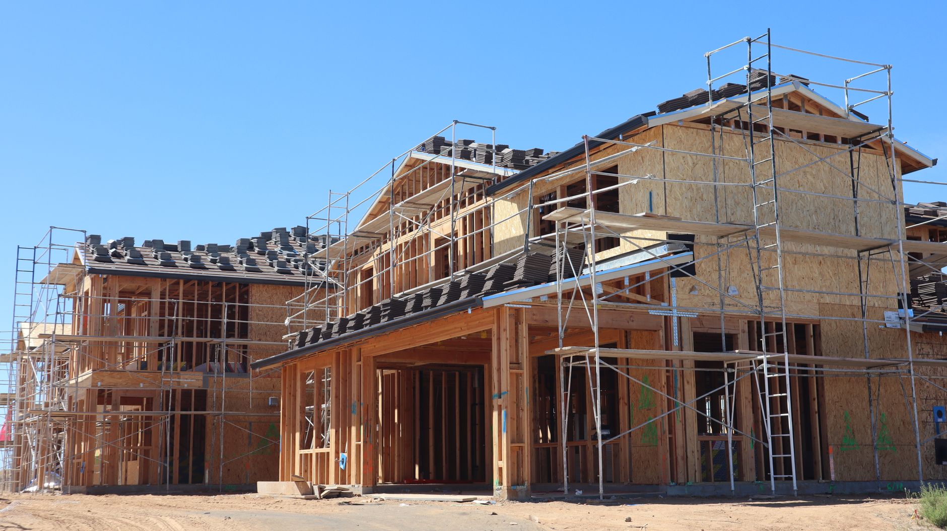 Completed housing modules ready for connection at a residential building site.