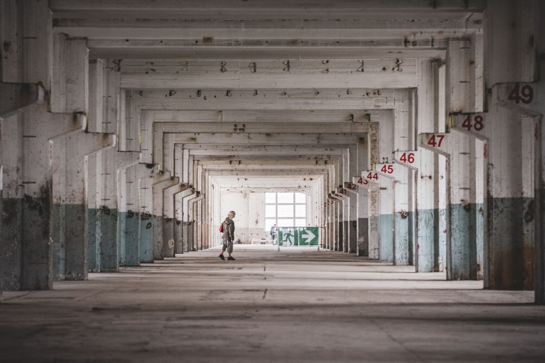 A long industrial corridor shows a polished concrete floor with safety striping.
