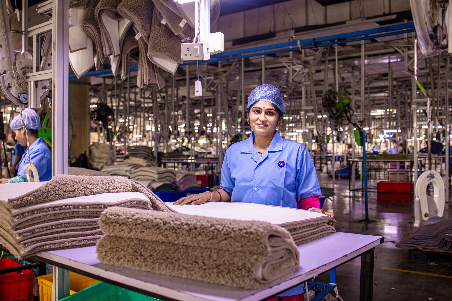 Workers move through a busy manufacturing floor with clear aisles connecting production areas.