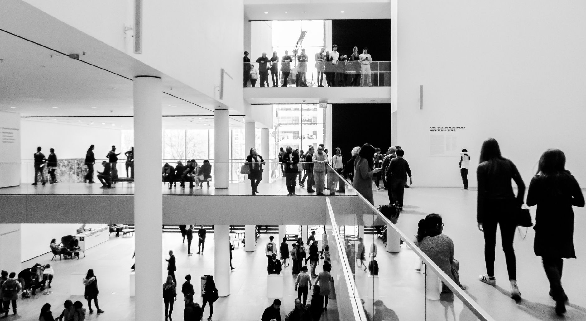 Visitors explore artworks in a spacious museum gallery during regular public hours.