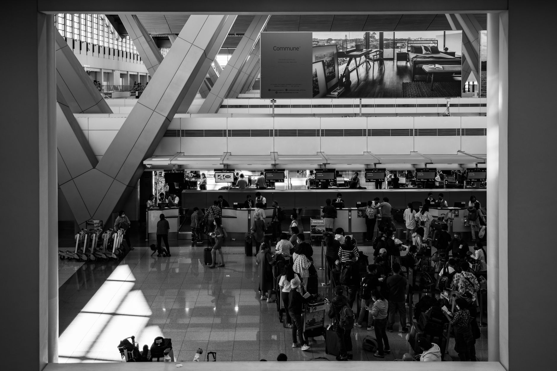 A dense crowd moves through a US-style intermodal terminal with open concourse space.