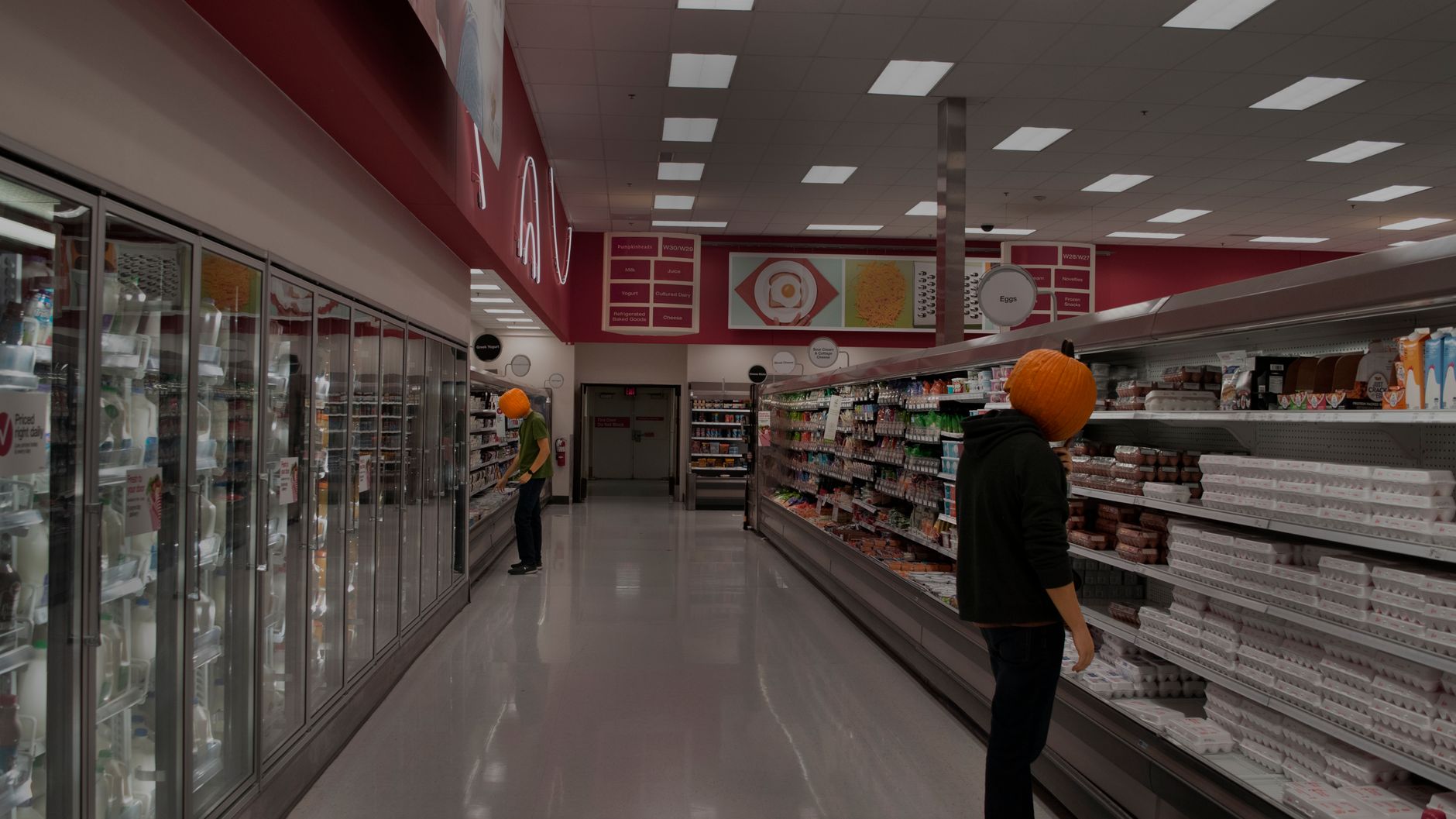 A long grocery corridor with bright lighting, illustrating the main sales-floor paths where large scrubbers run scheduled routes.