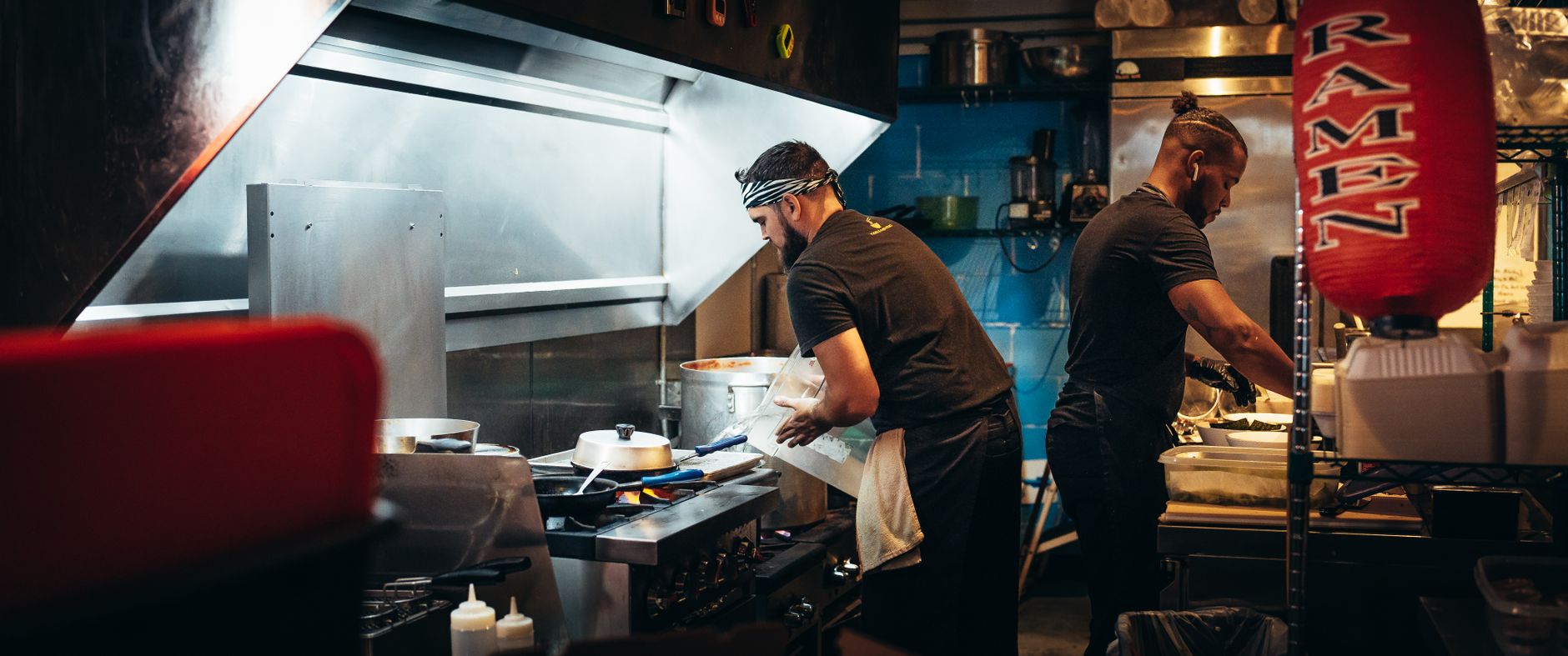 Fresh bowls of ramen wait at a commercial kitchen pass for delivery to diners.