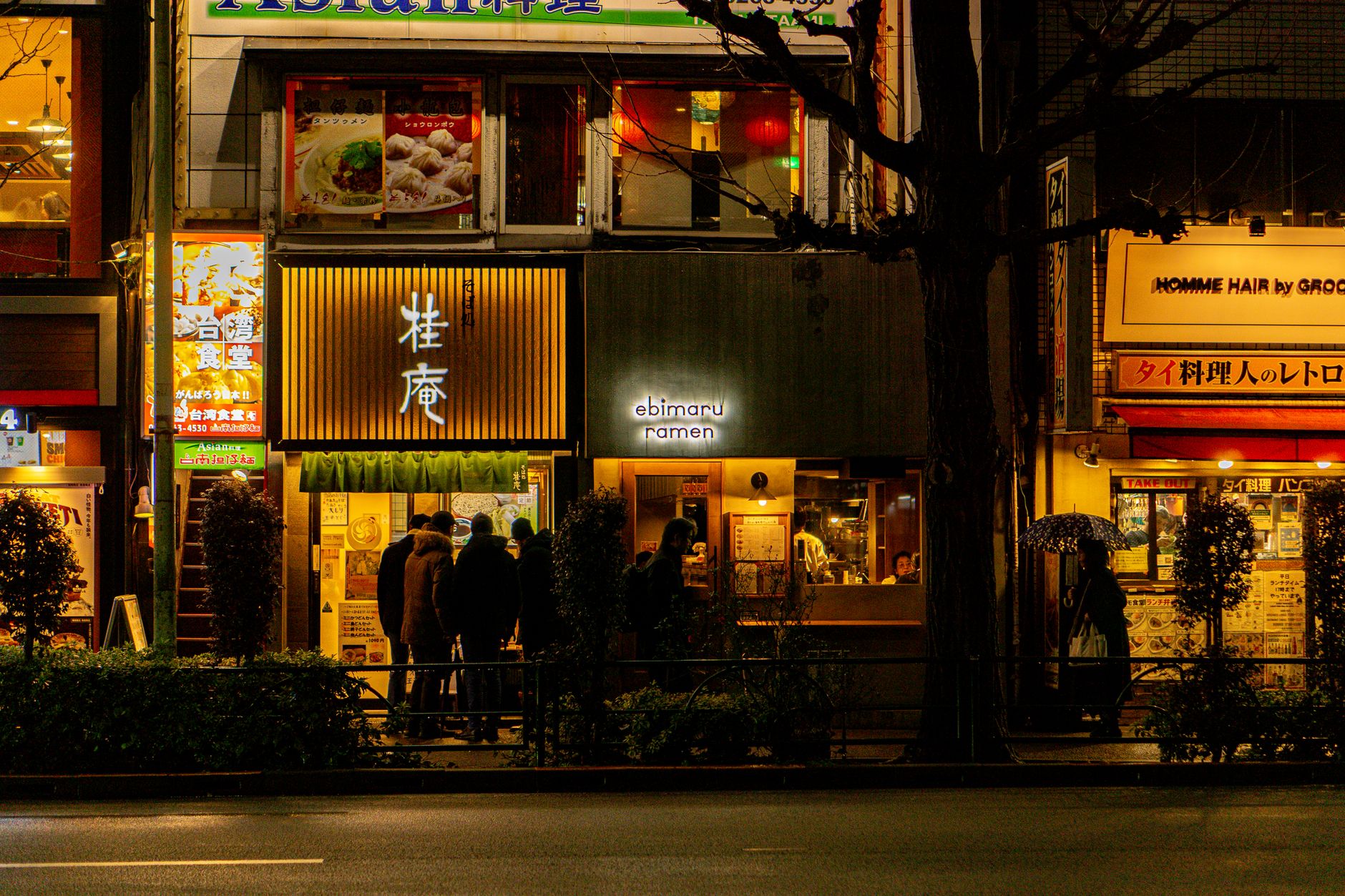Servers move through a busy ramen dining room during a peak meal period.