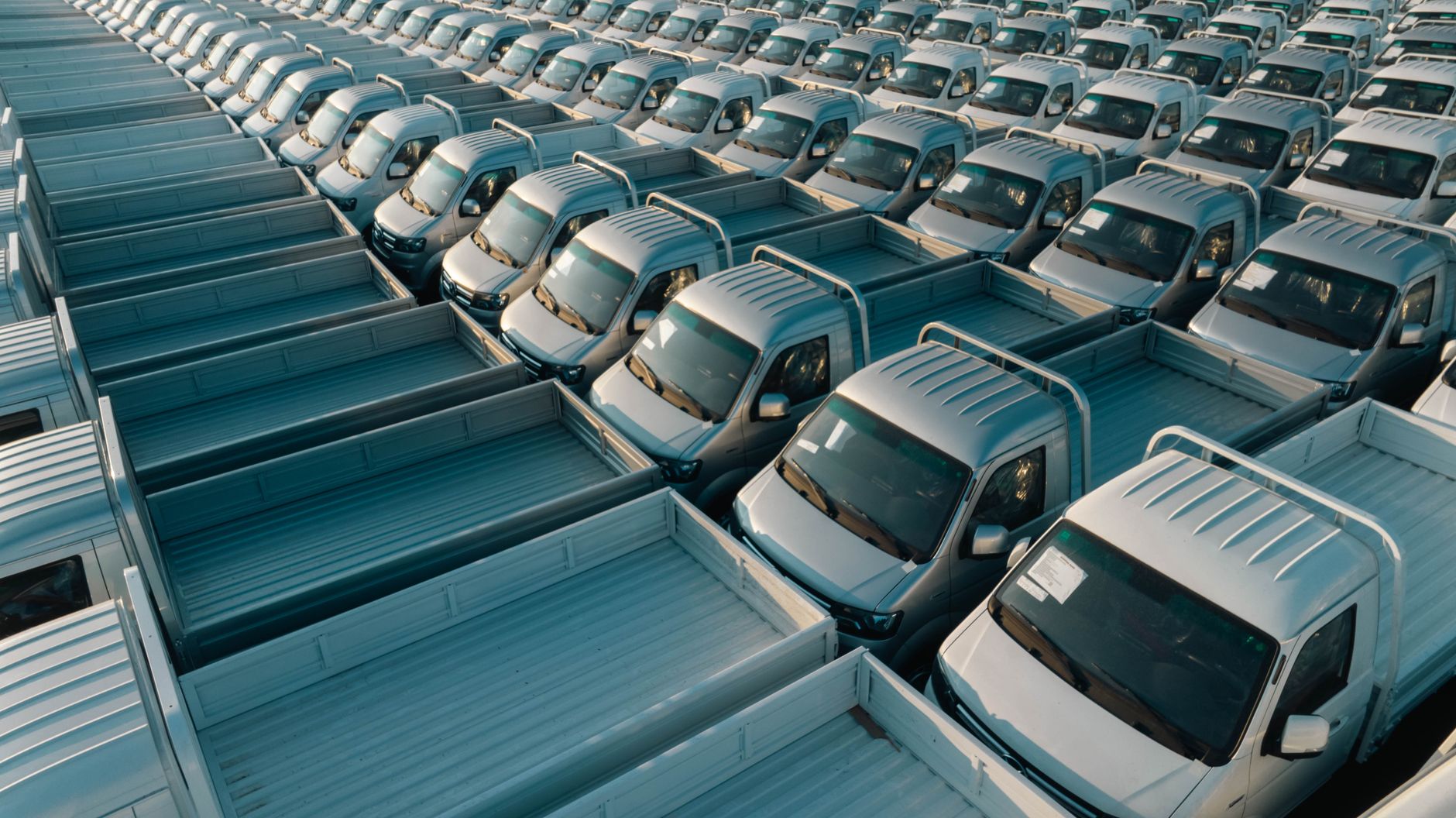 Wide view of an automotive manufacturing floor where internal material moves support production and welding cells.