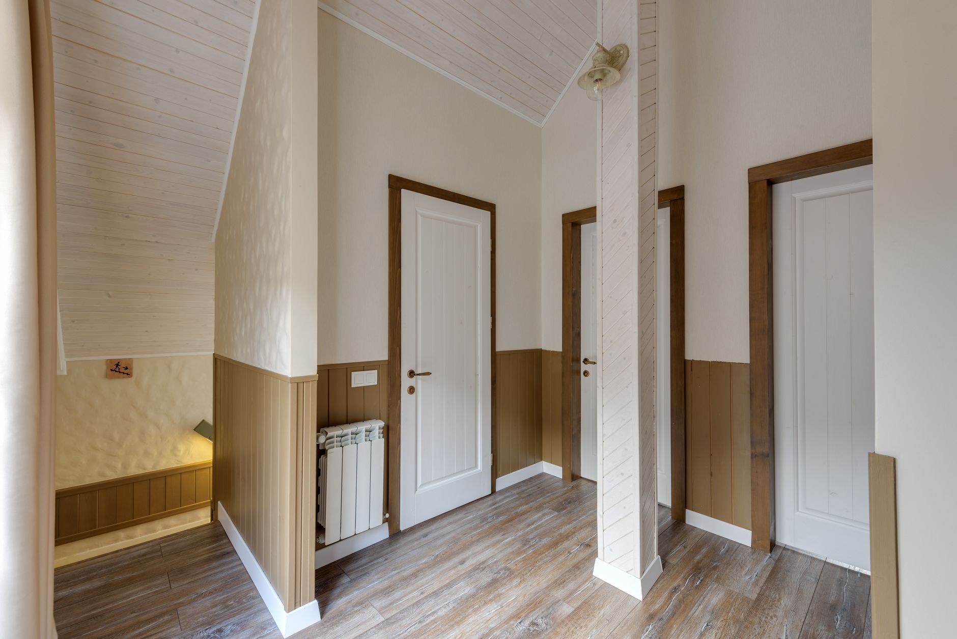 A bright interior hallway with reflective vinyl flooring that shows scuffs when crowds pass through.