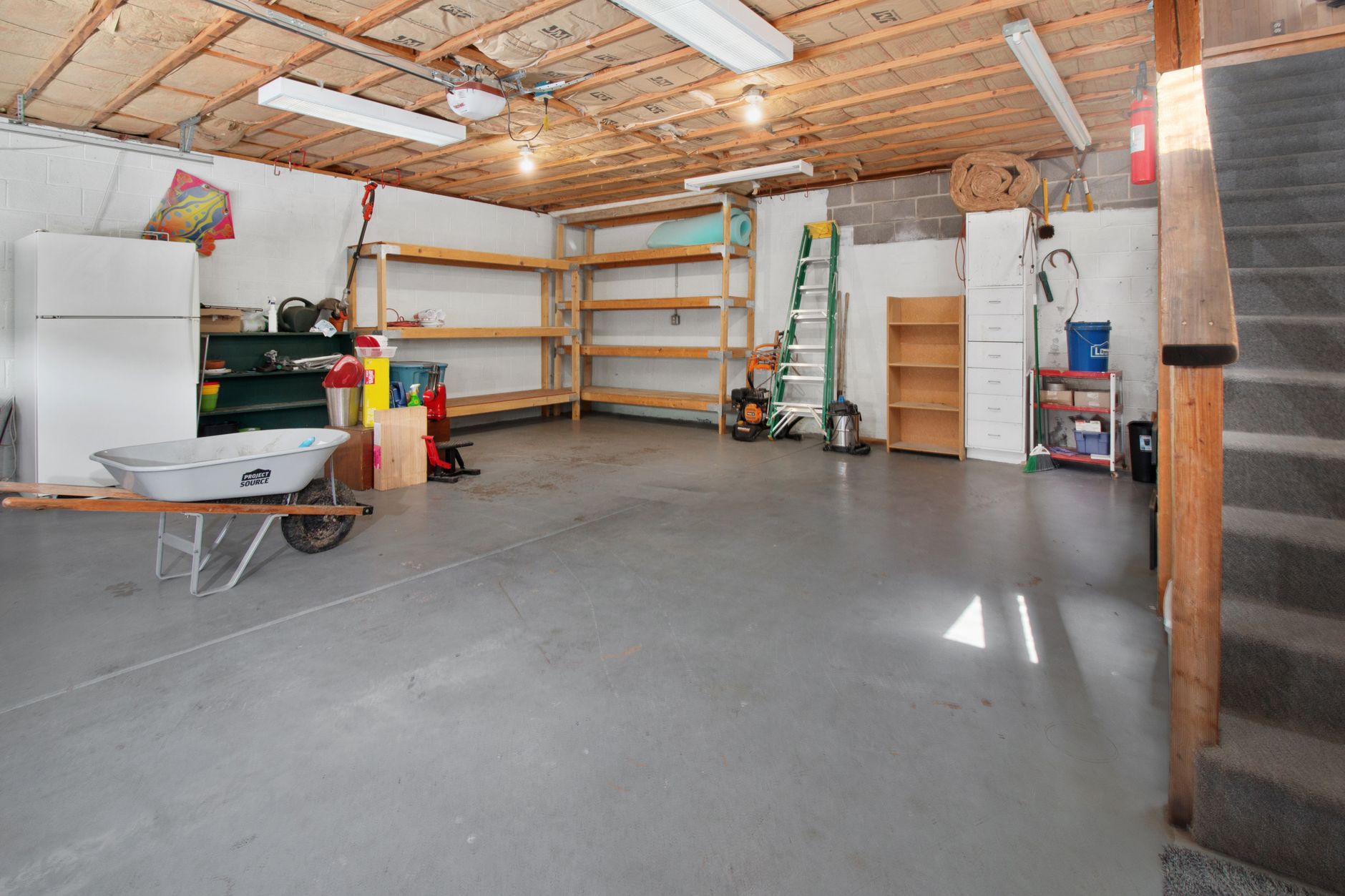 Glossy clean concrete floor in an industrial building reflecting overhead lights.
