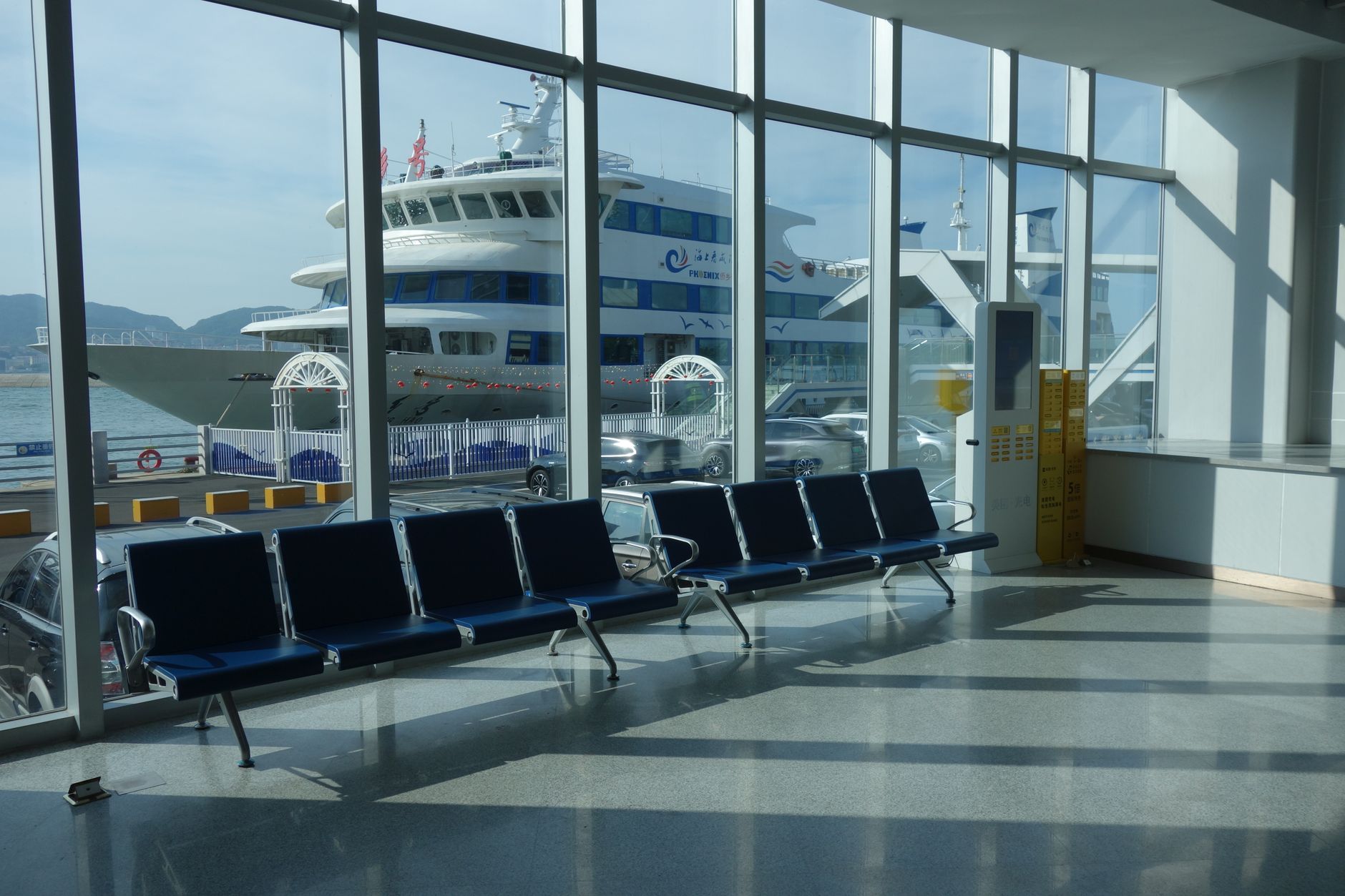 A spacious passenger terminal with hard floors and seating for cruise and ferry travelers.
