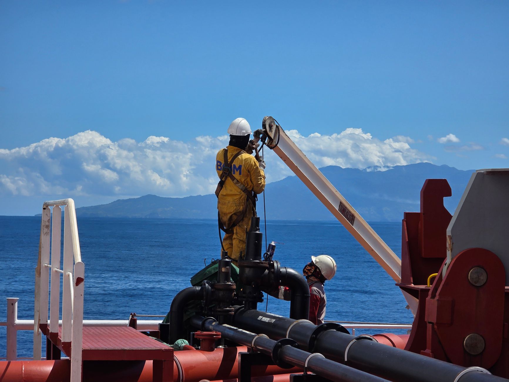 A rigging crew positions heavy equipment inside an industrial facility.