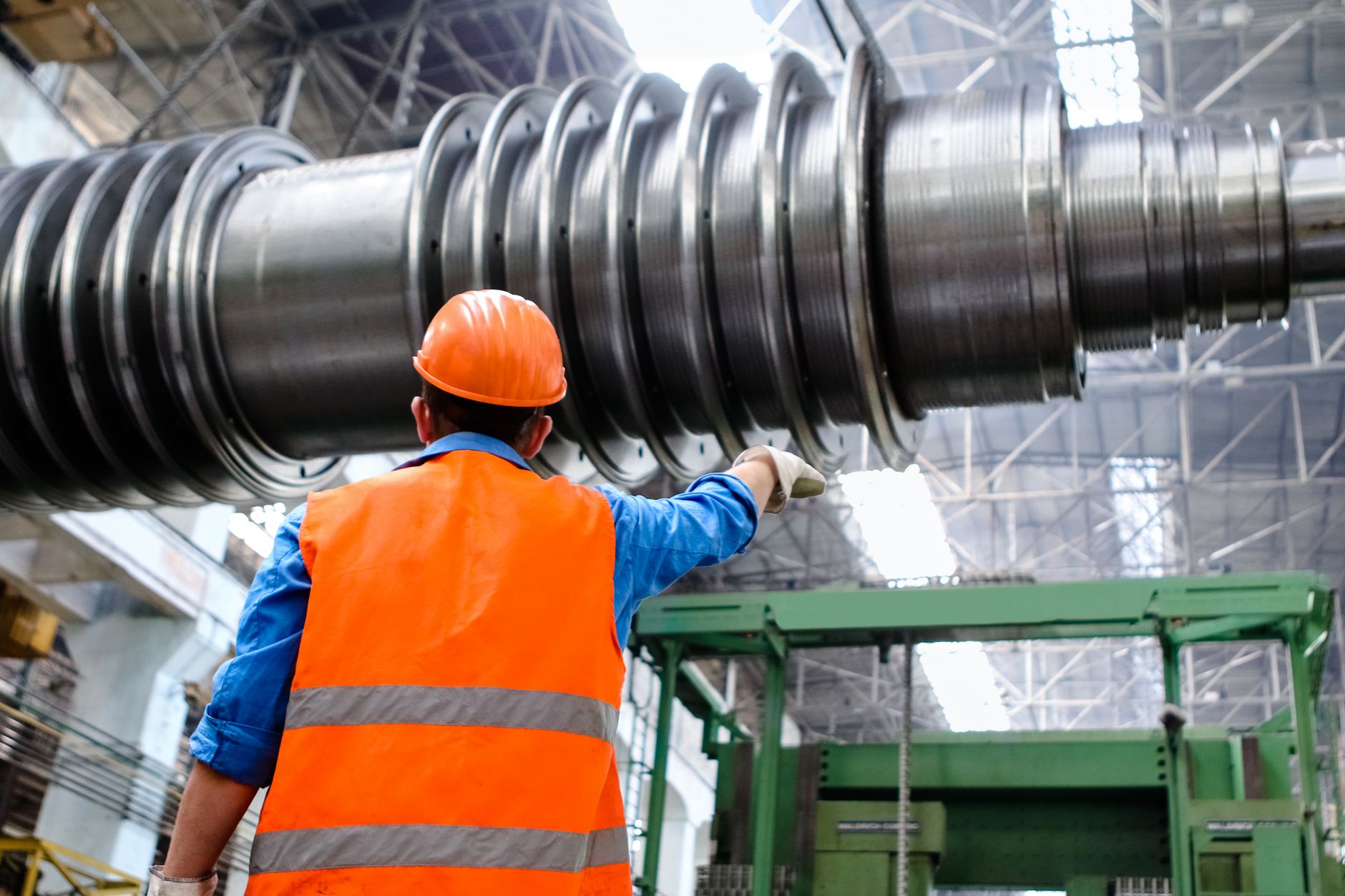 An engineer assesses equipment and site constraints on a factory floor.