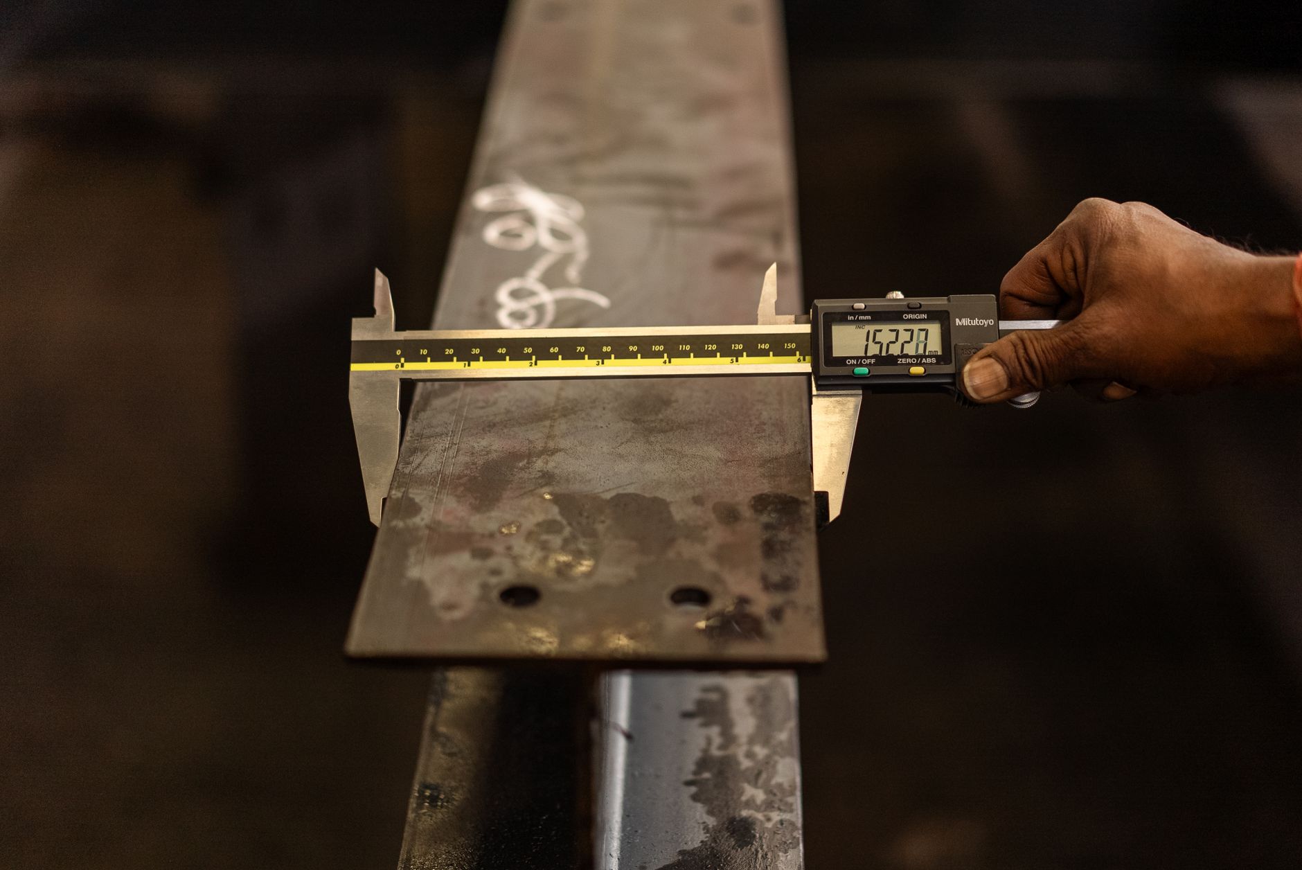 Hands using calipers to measure molded components during a quality check, echoing the scrap reduction described in the case study.