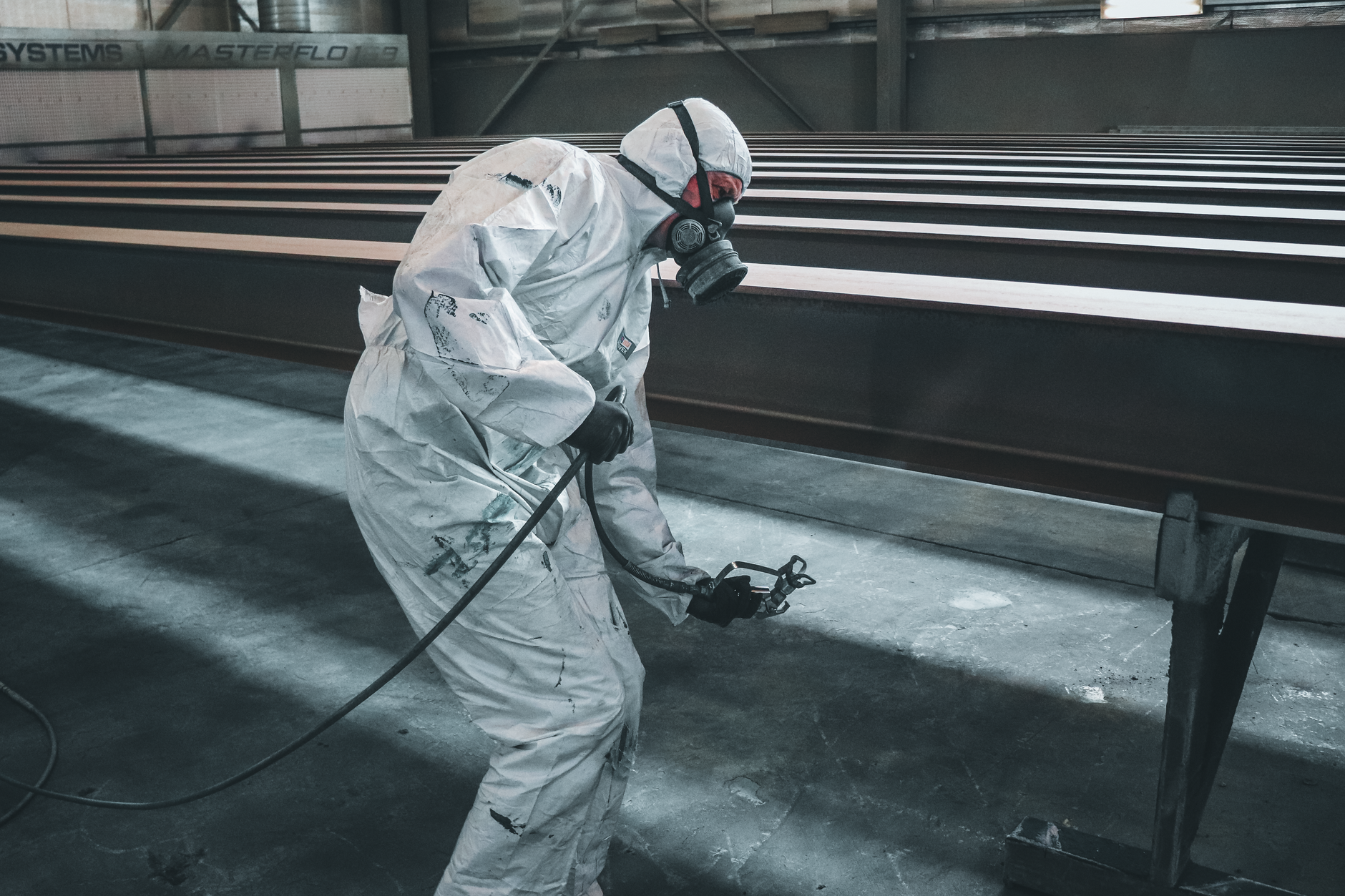 Finishing technician in protective gear for spray touch-up work