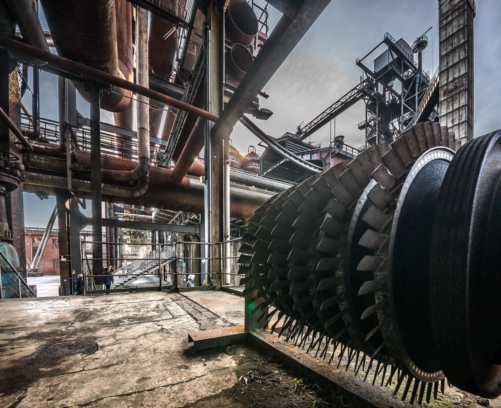 Inside a large power plant boiler facility with dense piping and steel structures.