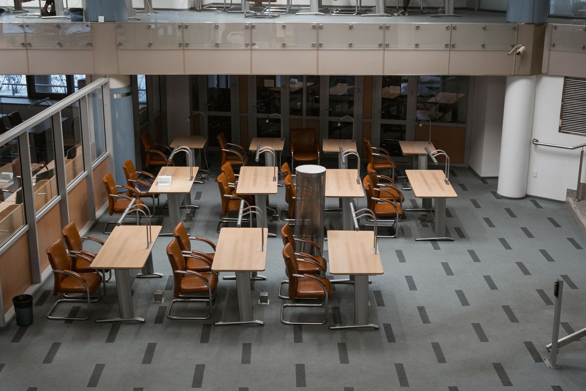 A cleaner caring for the floor in a spacious public library interior.