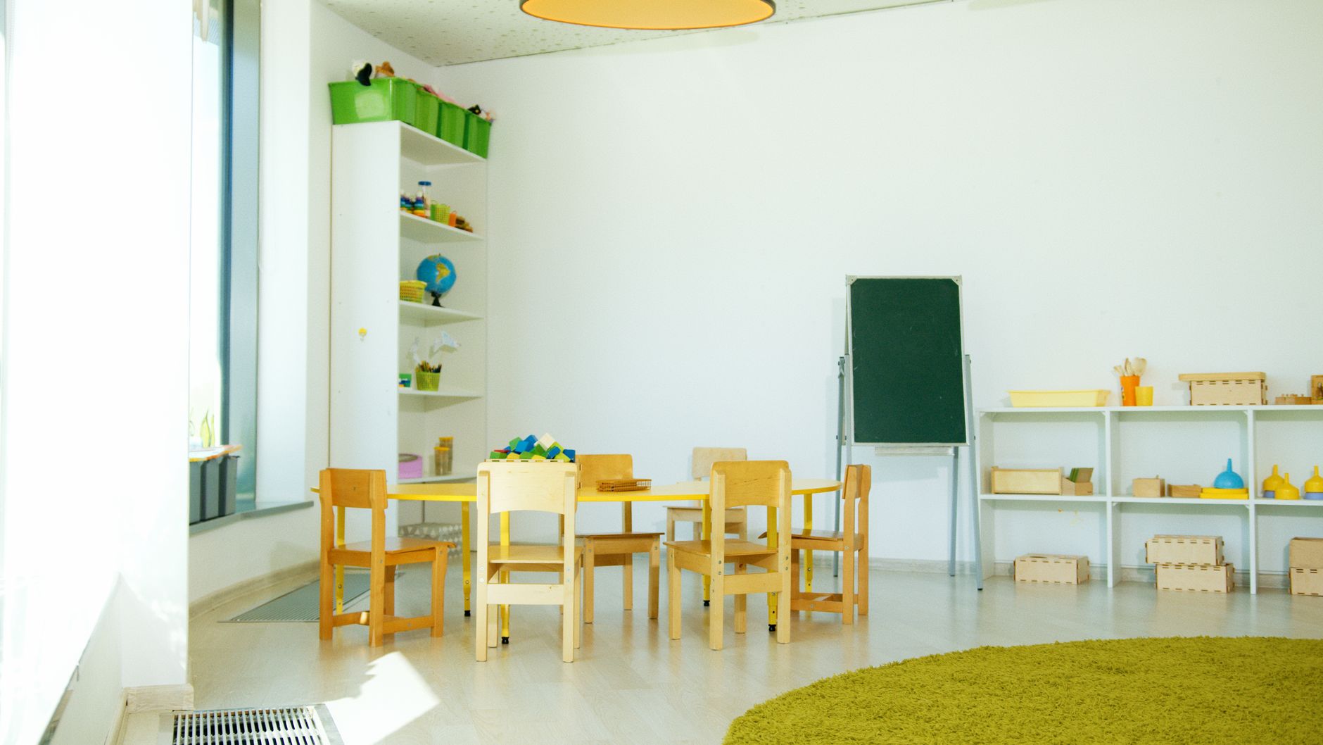 Carpeted classroom reading area with colorful rugs and student desks.