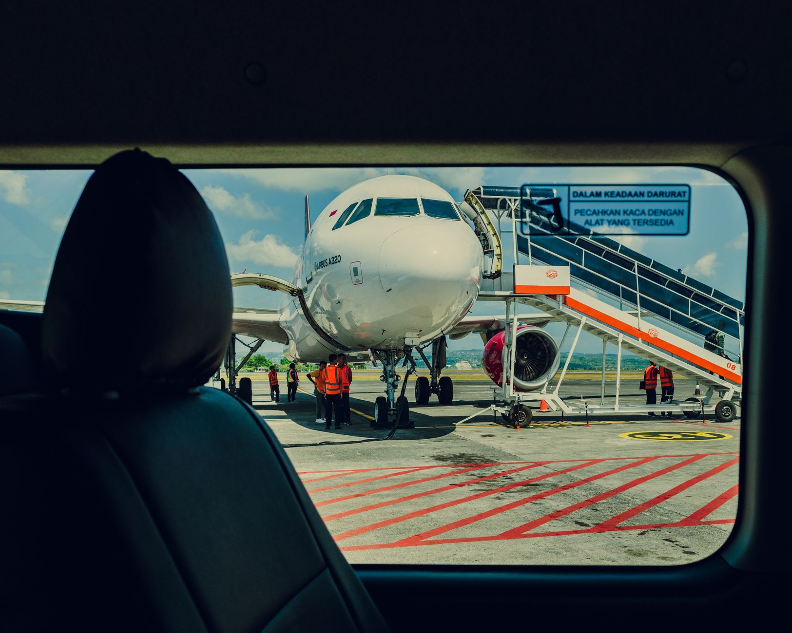 Airport cleaners focusing on detail work while a robotic scrubber handles open concourses.