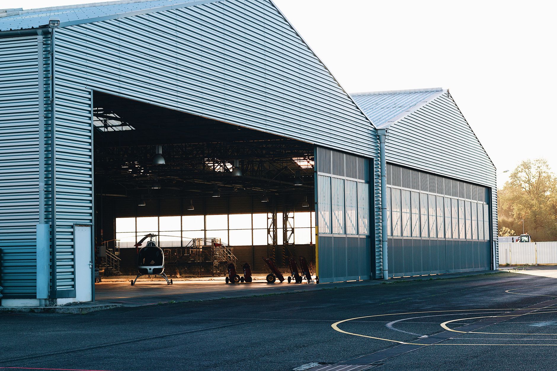 Hangars and apron at a reliever airport where reclaimed mowing hours can shift to building and marking upkeep.