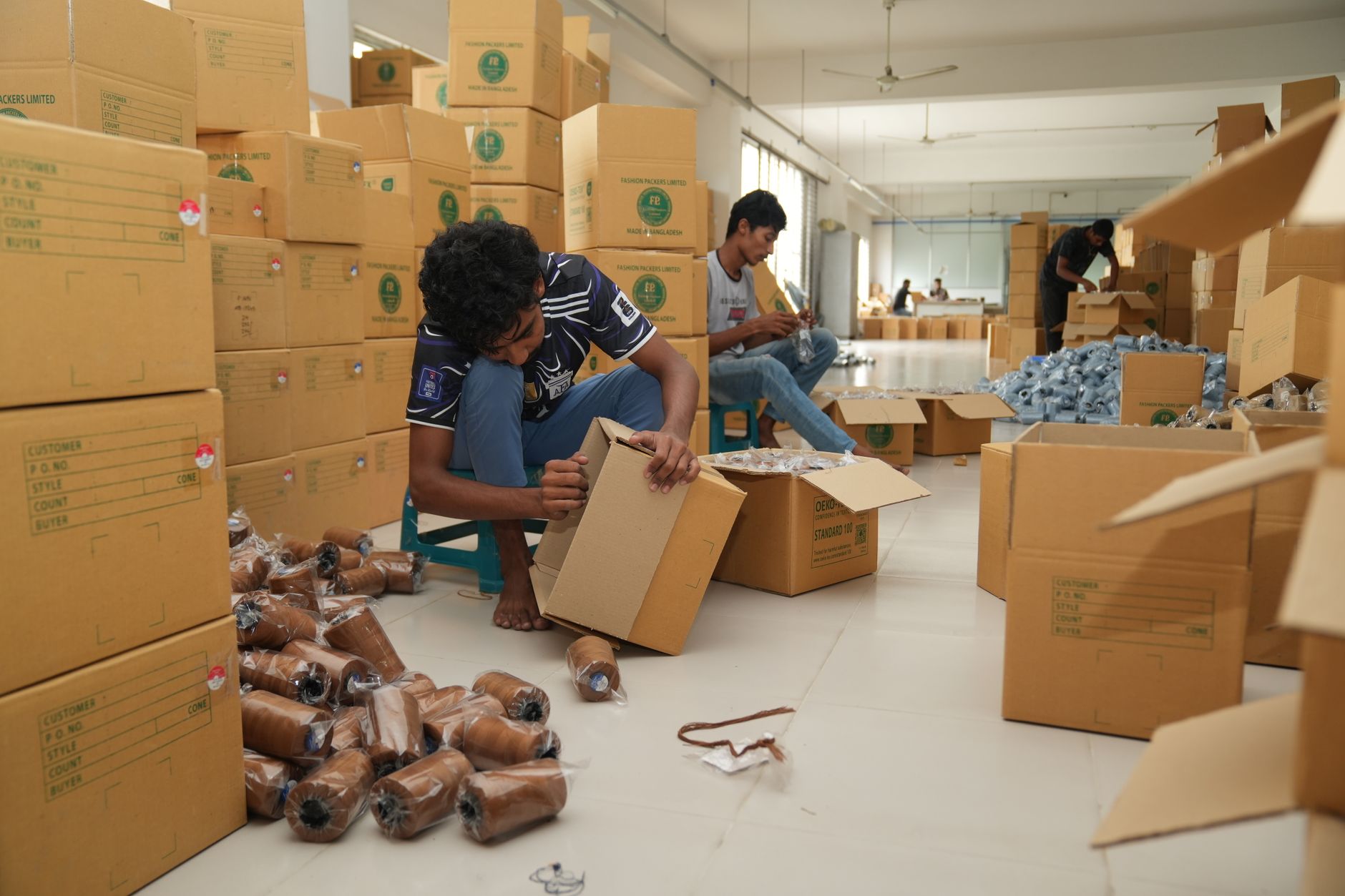 A worker folds and prepares cardboard cases for a packaging run.