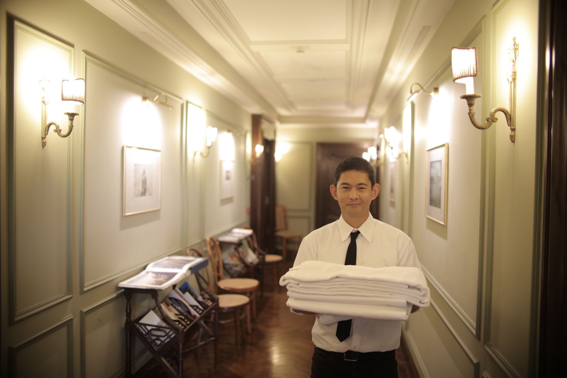 A quiet hotel corridor with housekeeping activity and clear walking space, illustrating how labor saved from floor care can support visible guest-facing operations.