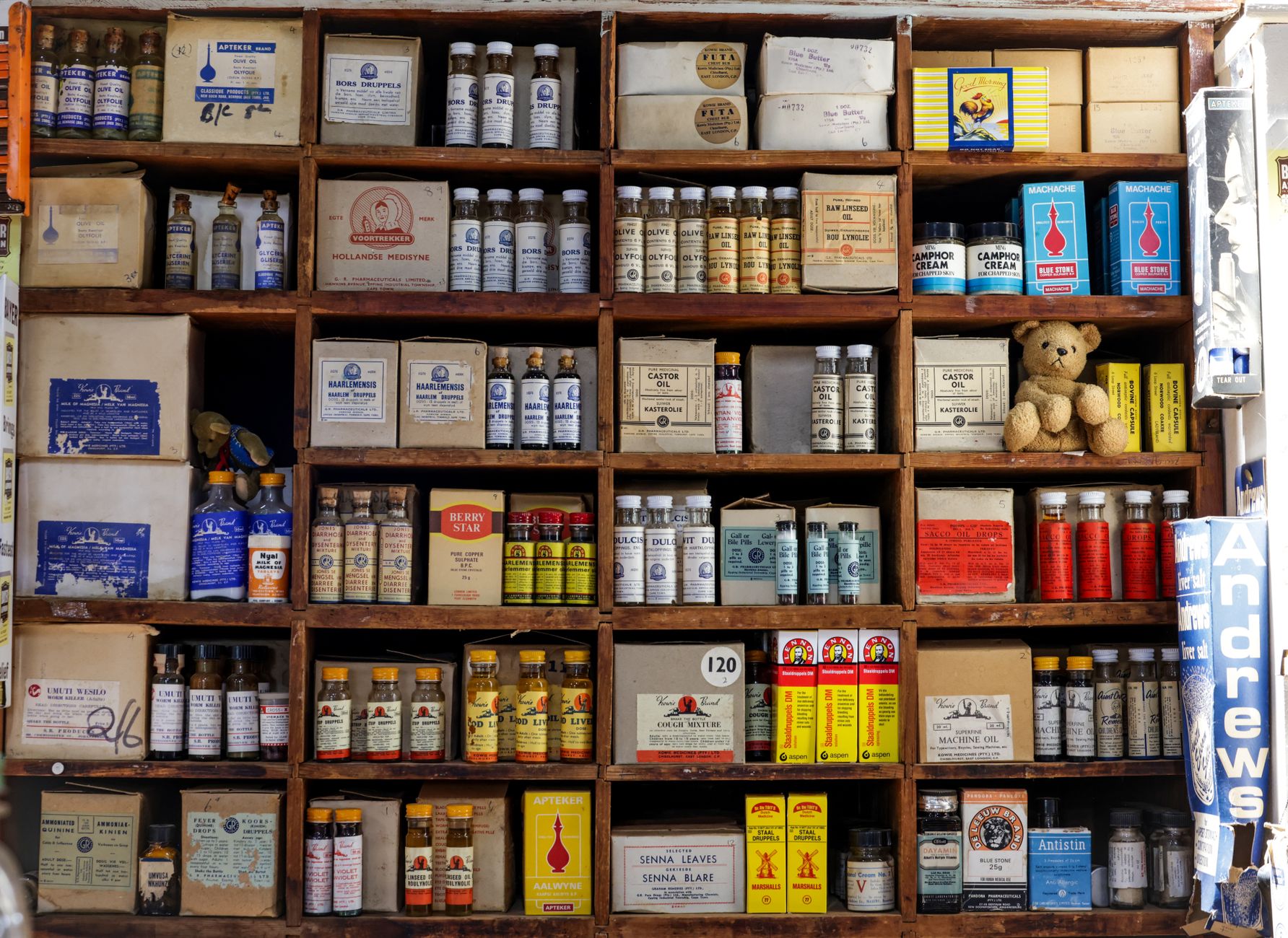 Shelves lined with boxed medicines in a retail stockroom before automated intake.